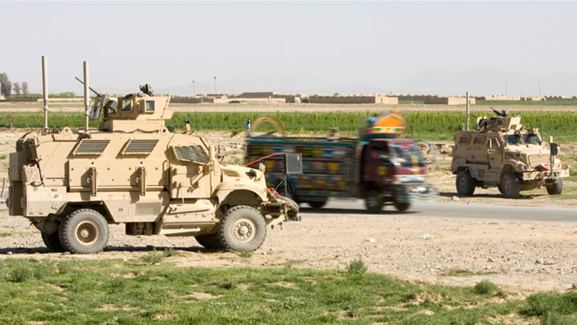 March 25, 2010: An Afghan truck is driven past U.S. Army Mine Resistant Ambush Protected (MRAP) armored vehicles of 508th Special Troops Battalion, 82nd Airborne Division, at an Afghan Police checkpoint on the Highway One, the main Afghan road around the country, outside the town of Kandahar, southern Afghanistan. Police and sheriff's departments in the U.S. have obtained 165 MRAP vehciles leftover from the Iraq war.