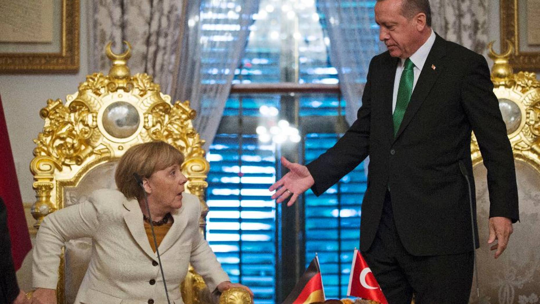 Turkish President Recep Tayyip Erdogan, right, offers his hand to shake hands with Germany's Chancellor Angela Merkel, left, following a joint statement after their meeting in Istanbul, Sunday, Oct. 18, 2015. Merkel met with Turkish leaders to promote a EU plan that would offer aid and concessions to Turkey in exchange for measures to stem the mass movement of migrants across Europe's borders. (Tolga Bozoglu, Pool Photo via AP)
