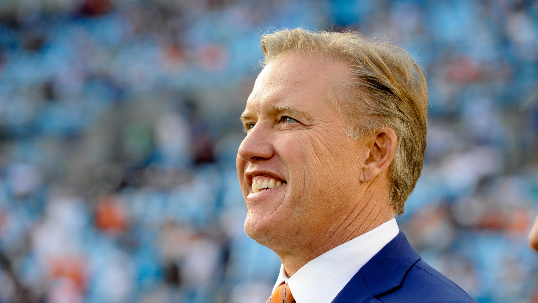 FILE - This is a Nov. 11, 2012 file photo showing Denver Broncos executive vice president, John Elway, watching players warm up prior to an NFL football game between the Carolina Panthers and the Denver Broncos in Charlotte, N.C. Elway could very well be directing his greatest comeback from a leather chair in an office. (AP Photo/Mike McCarn, File)
