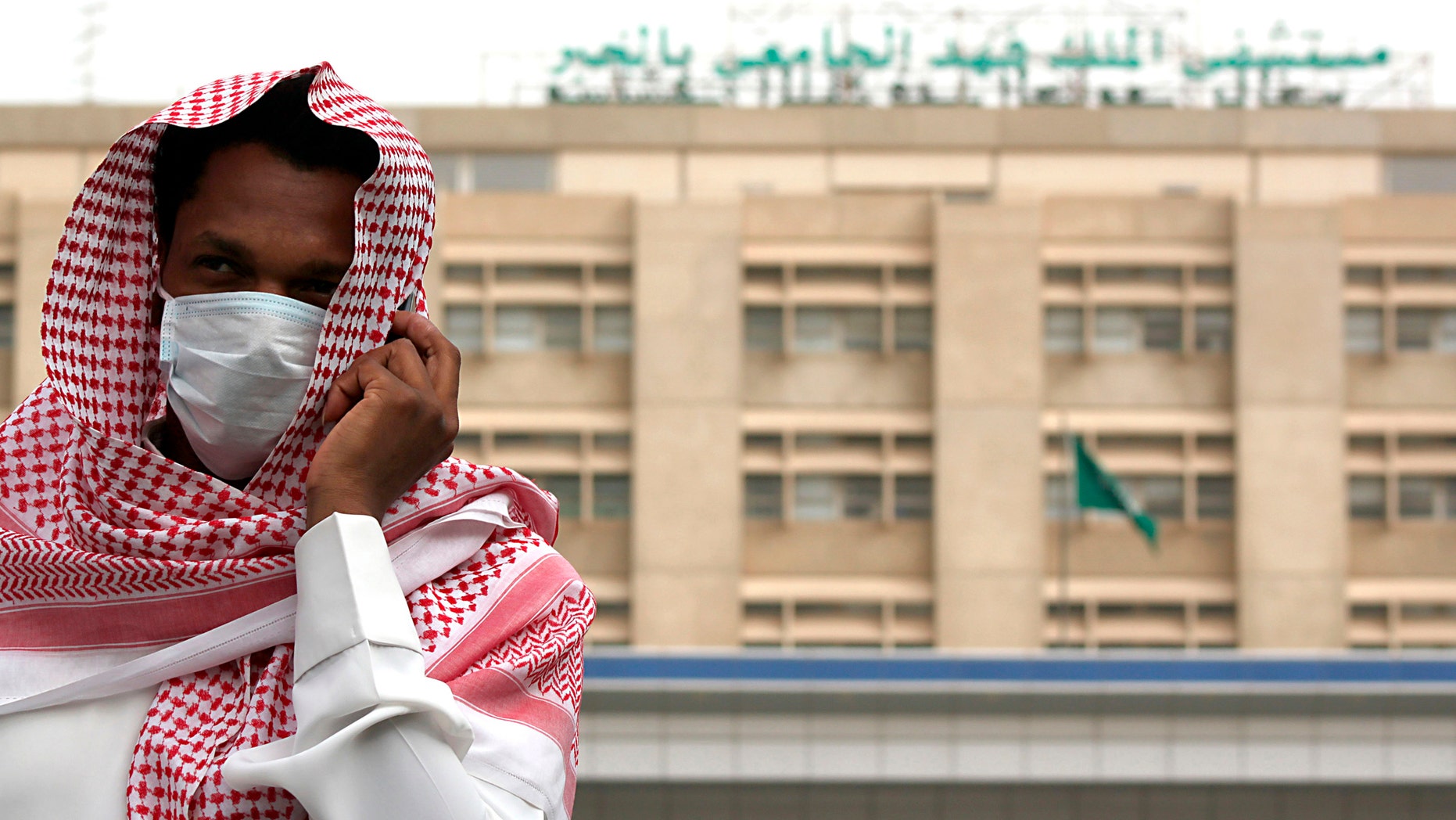 A man, wearing a surgical mask as a precautionary measure against the novel coronavirus, walks near a hospital in Khobar city in Dammam May 21, 2013.