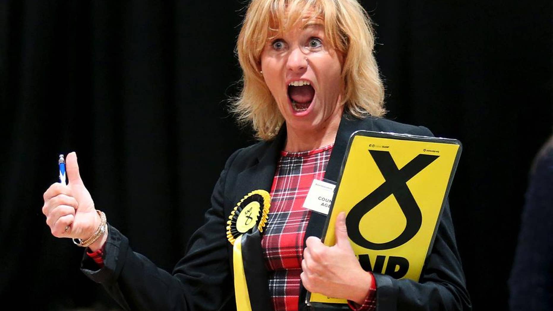 A Scottish National Party (SNP) election canvasser reacts as she views ballot papers being counted for the Banff and Buchan, Gordon, and West Aberdeenshire and Kincardine constituency counts in Britain's election at the Aberdeen Exhibition and Conference Centre in Aberdeen, Scotland Friday May 8, 2015. (Andrew Milligan/PA via AP) UNITED KINGDOM OUT, NO SALES, NO ARCHIVE