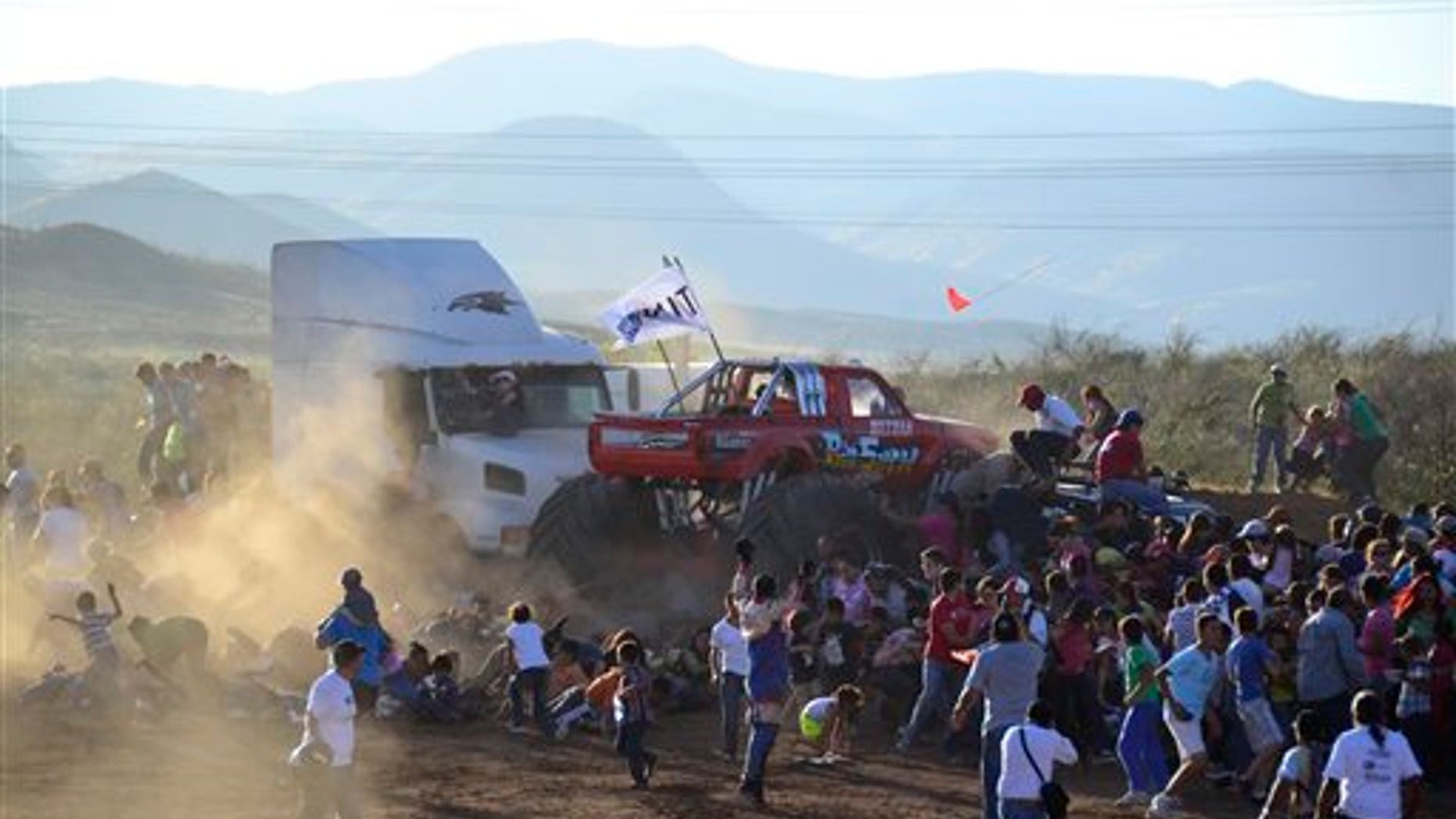 People run as an out of control monster truck plows through a crowd of spectators in the city of Chihuahua, Mexico, Saturday Oct. 5, 2013.