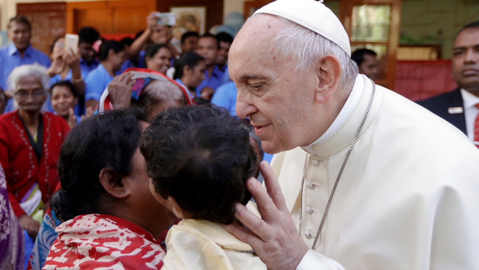 Pope Francis kisses a child as he meets with sick people and staff of the Mother Teresa House in Dhaka's Tejgaon neighborhood, Bangladesh, Dec. 2, 2017.