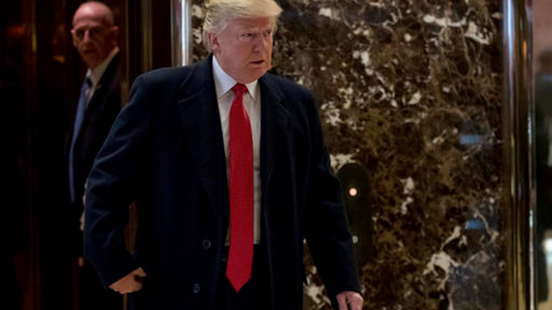 President-elect Donald Trump comes to the lobby to speak to members of the media at Trump Tower in New York, Tuesday, Dec. 6, 2016.