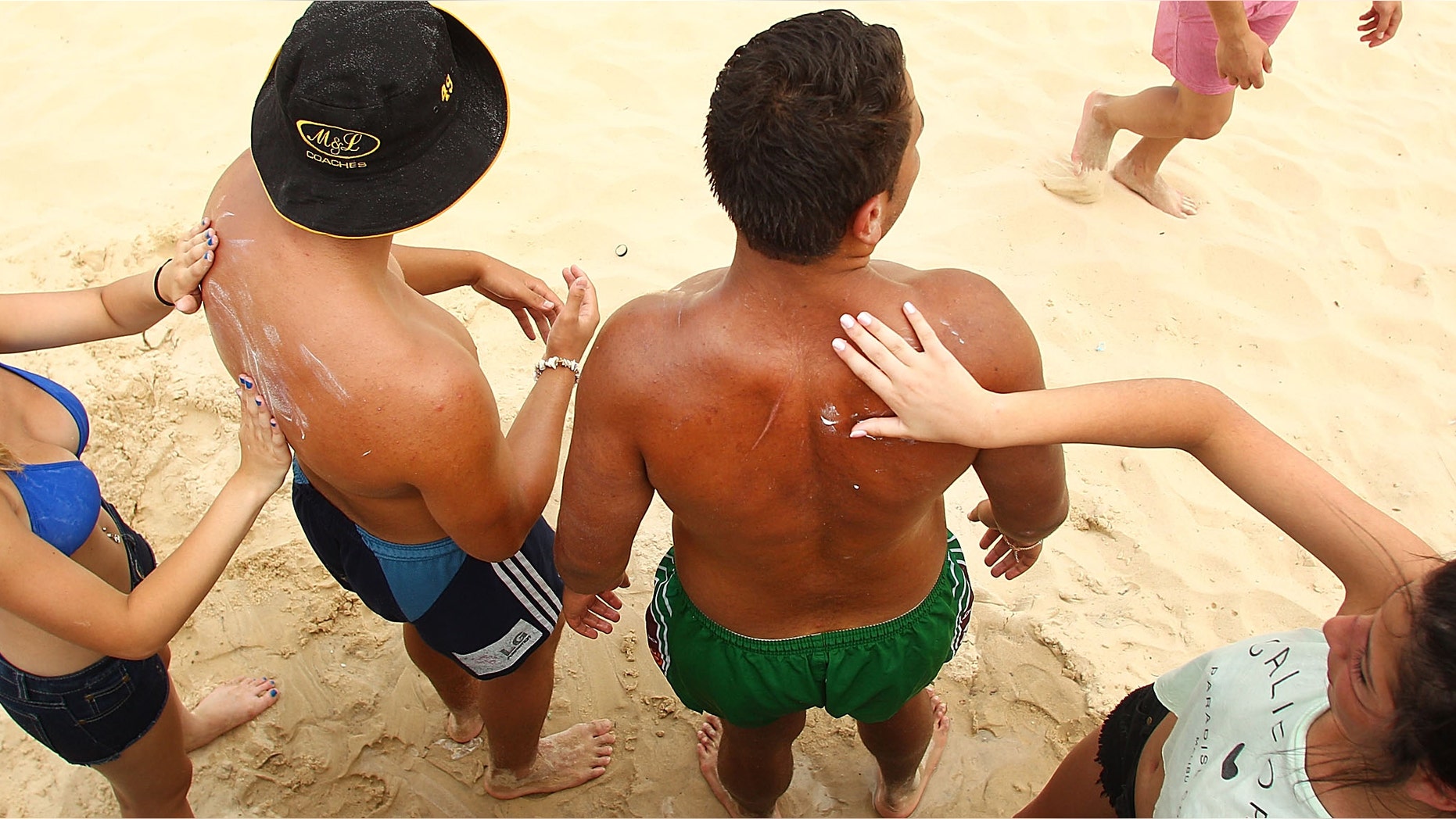 SYDNEY, AUSTRALIA - JANUARY 08: Beach-goers apply sunscreen to each other at Bondi Beach on January 8, 2013 in Sydney, Australia. Temperatures are expected to reach as high as 43 degrees around Sydney today. (Photo by Marianna Massey/Getty Images)