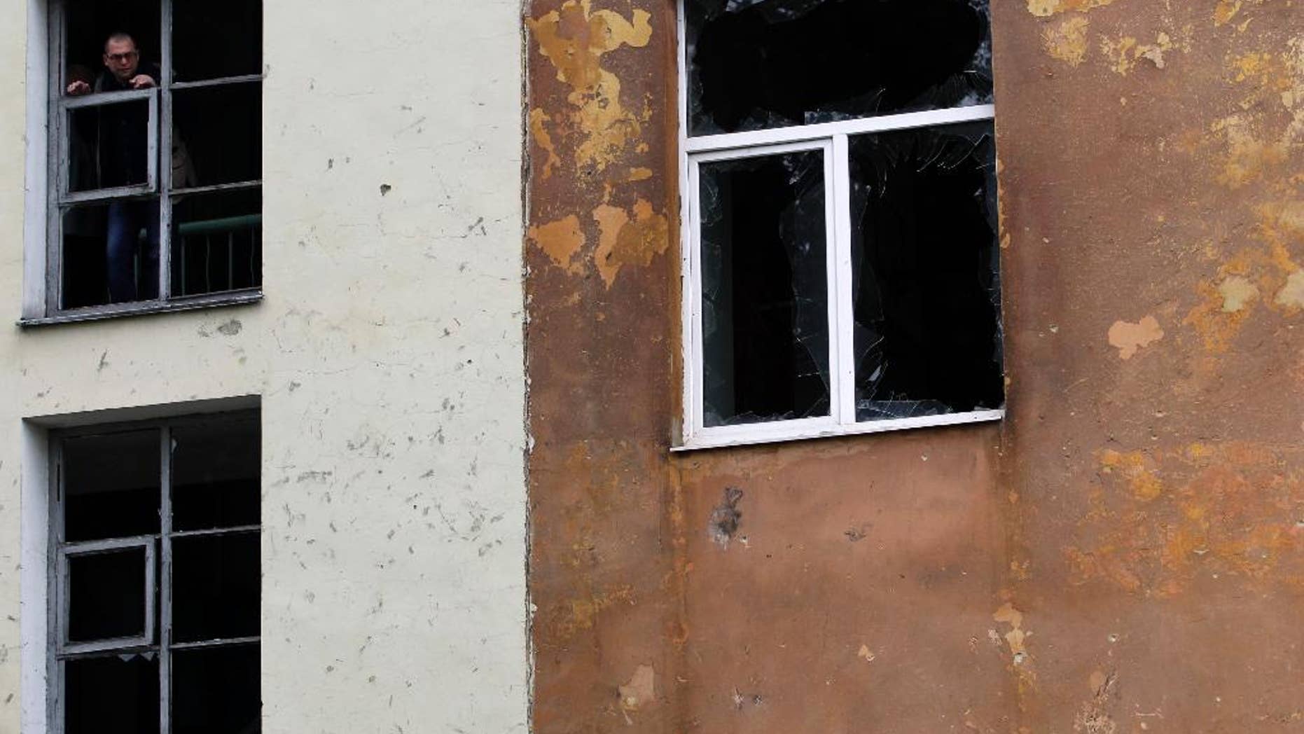 Sept. 24, 2014: A man observes the damage of a building after shelling in the town of Donetsk, eastern Ukraine. Mortar fire struck an apartment block in the rebel-held city of Donetsk overnight, yet another violation of a cease-fire declared weeks earlier between government forces and pro-Russian insurgents.