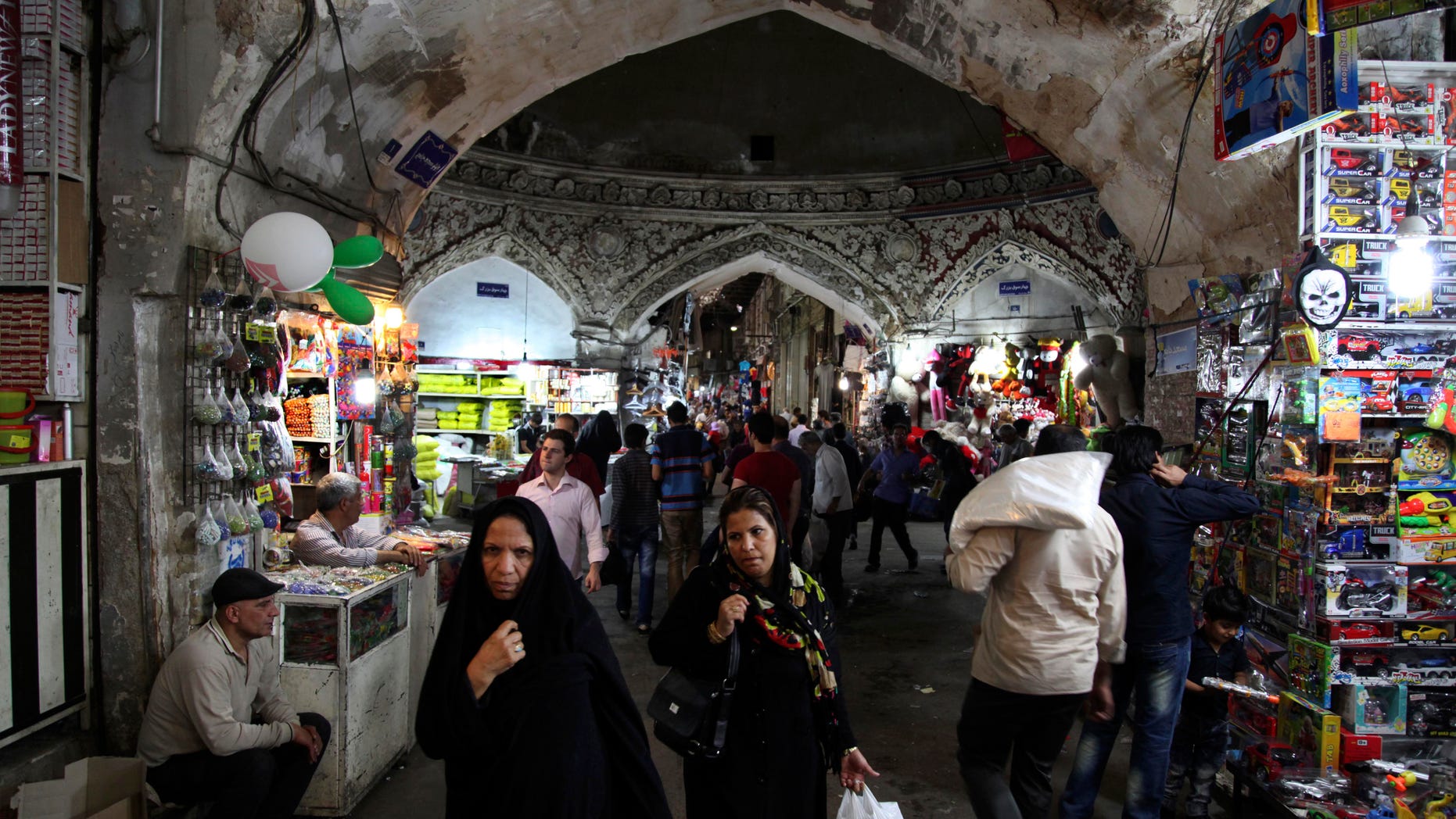 Iranians walk in the old bazaar, in Tehran, Iran, on Sunday, May 12, 2013. On Saturday former President Akbar Hashemi Rafsanjani's made a last minute surprise decision to enter Iran's presidential election process, which now includes more than 680 hopefuls and will culminate June 14 with just a handful of names on the ballot to succeed Mahmoud Ahmadinejad. In one of his first statements since joining the race, Rafsanjani spoke in general terms Sunday of seeking a new ``economic and political'' rebirth in a time of ``foreign threats and sanctions.'' (AP Photo/Vahid Salemi)
