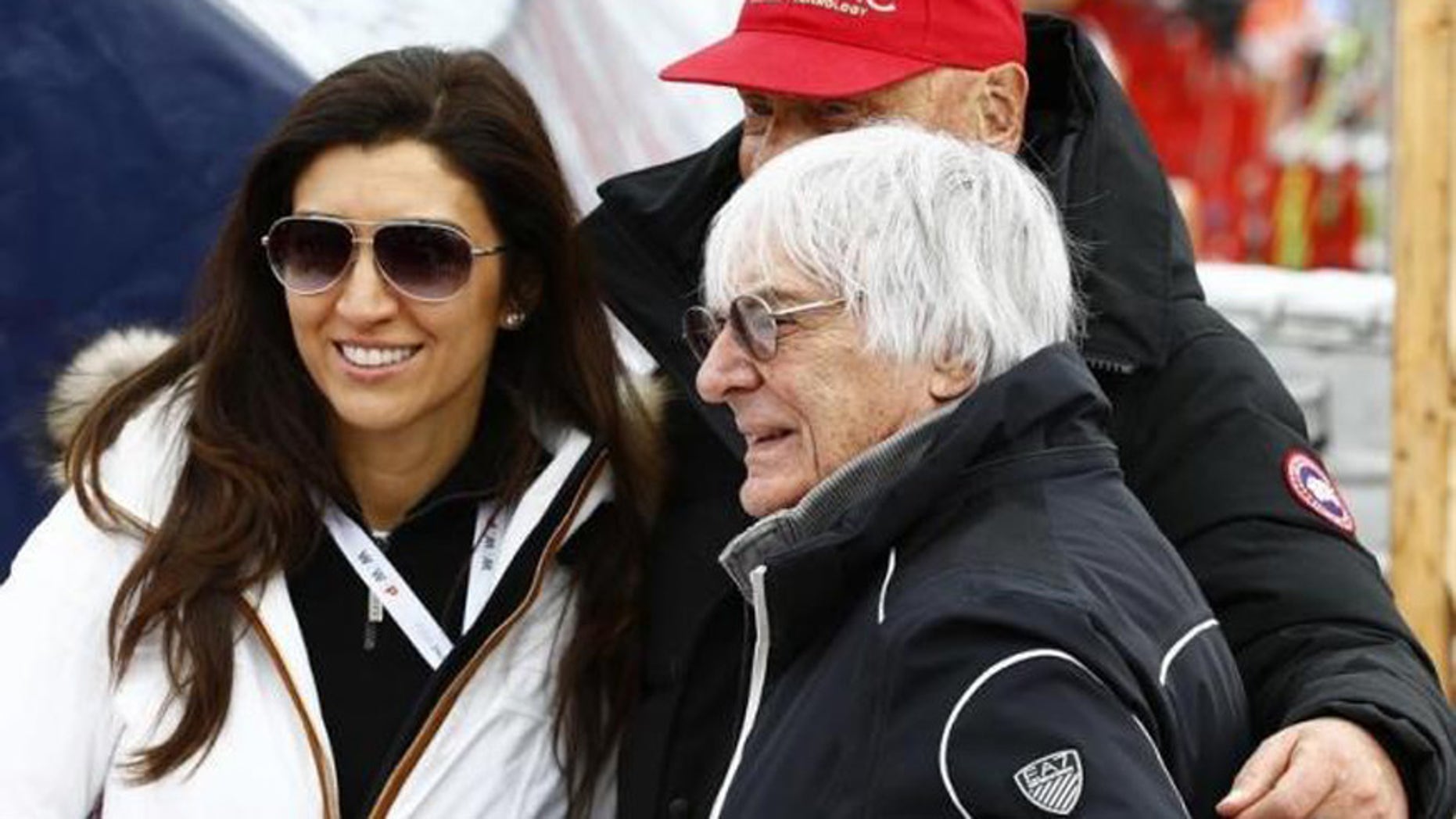Fabiana Flosi (L) and Bernie Ecclestone (R), pose with Formula One champion Niki Lauda (rear)