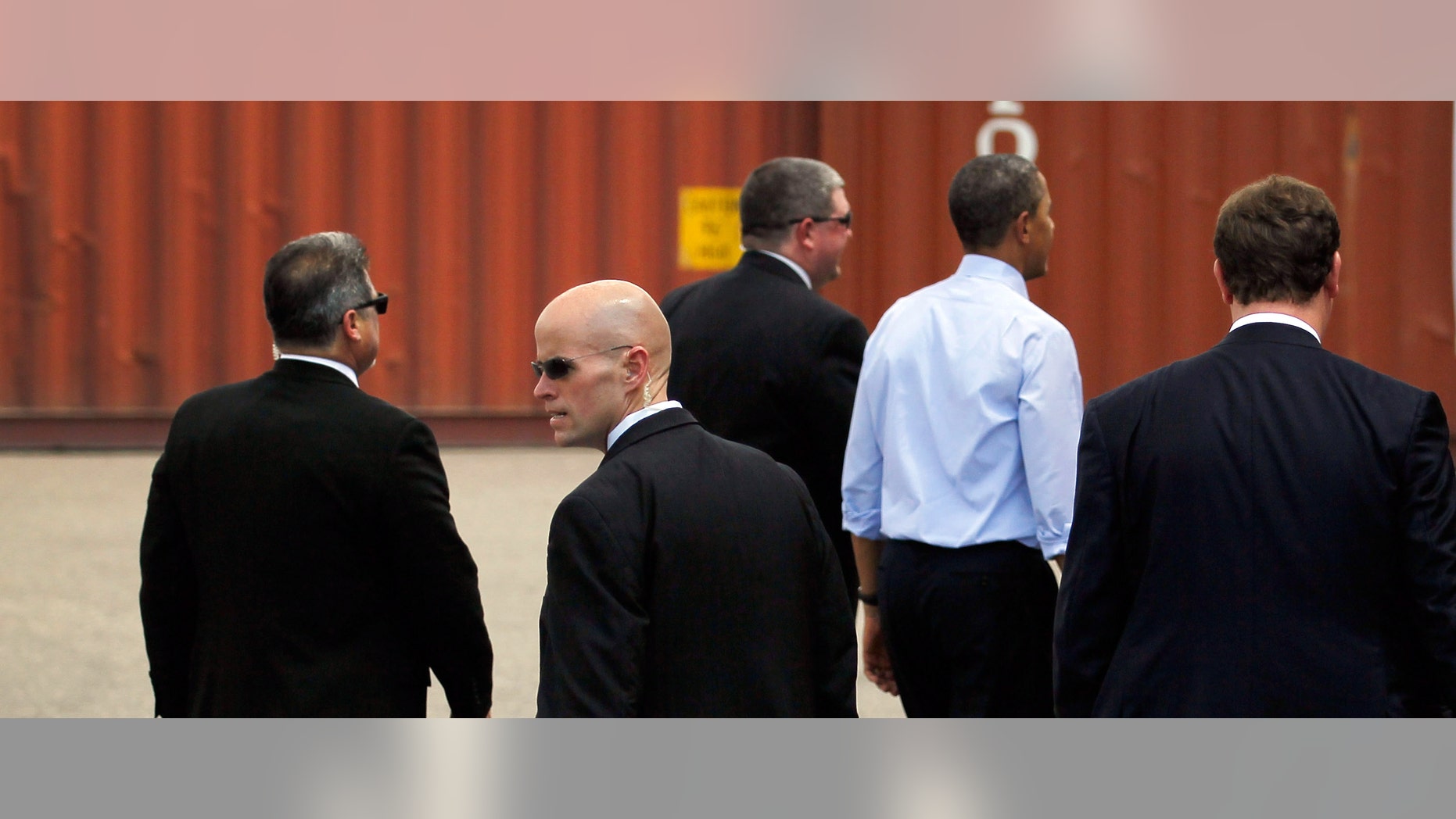 TAMPA, FL - APRIL 13: U.S. President Barack Obama (blue shirt) surrounded by Secret Service agents walks away after a visit to the Port of Tampa on April 13, 2012 in Tampa, Florida. The President, on his way to the Summit of the Americas in Colombia, used the visit to emphasis small business trade with countries in Latin America. (Photo by Joe Raedle/Getty Images)