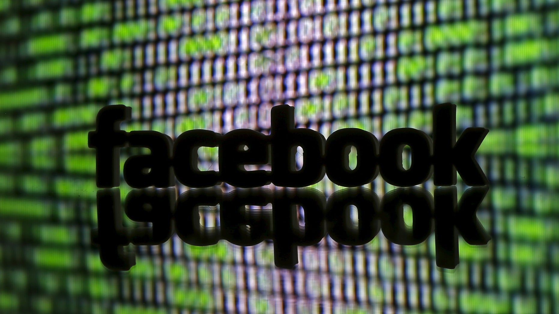 A 3D printed Facebook logo is seen in front of a displayed cyber code in this illustration taken March 22, 2016. (REUTERS/Dado Ruvic/Illustration)