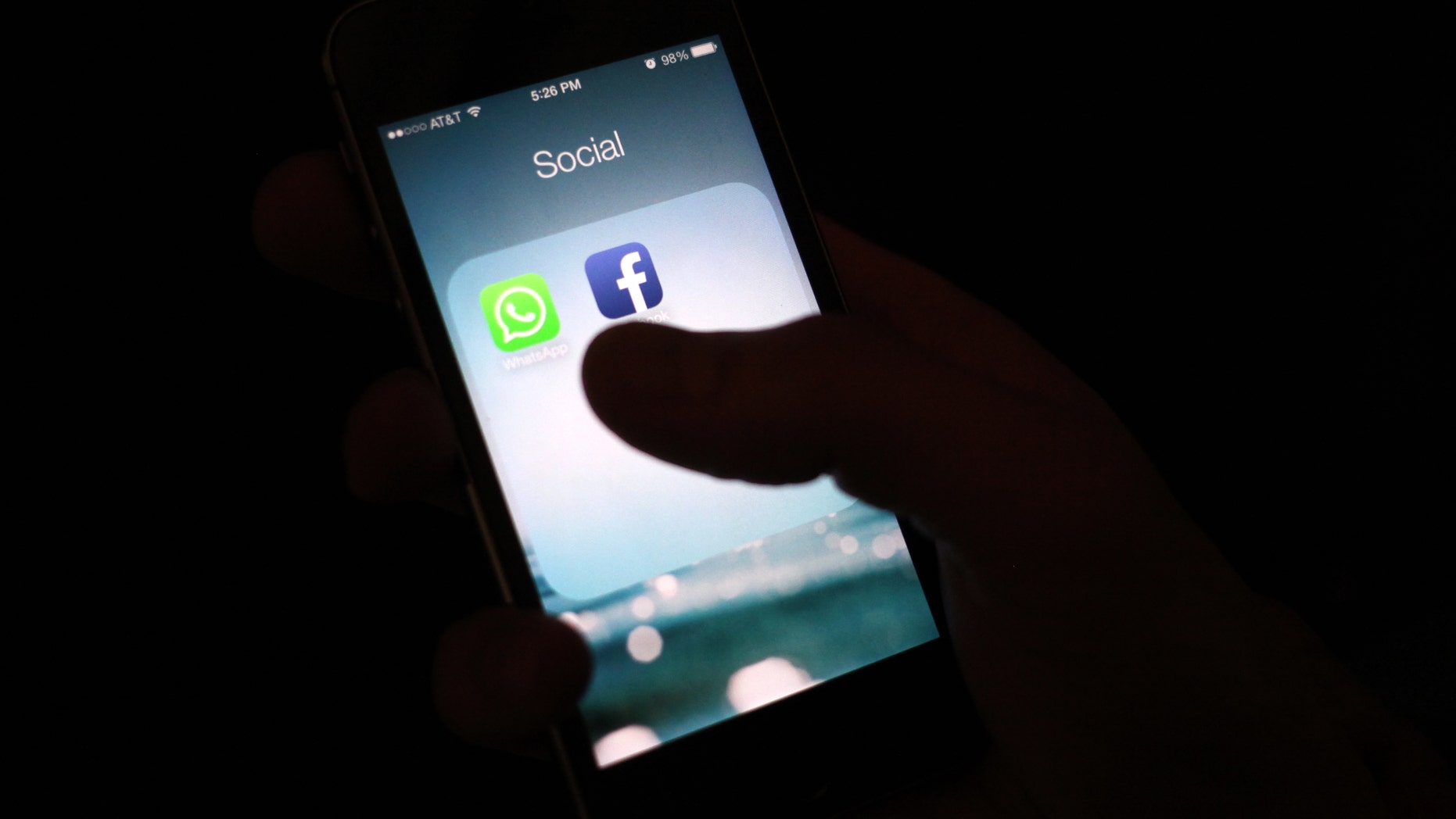 FILE - This Feb. 19, 2014, file photo shows the Facebook app icon on an iPhone in New York. A feature rolling out Tuesday, April 5, 2016, on Facebook's iPhone app interprets what's in a photo using a form of artificial intelligence to recognize faces and objects for blind and visually impaired people as they scroll through the pictures posted on the world's largest online social network (AP Photo/Karly Domb Sadof, File)