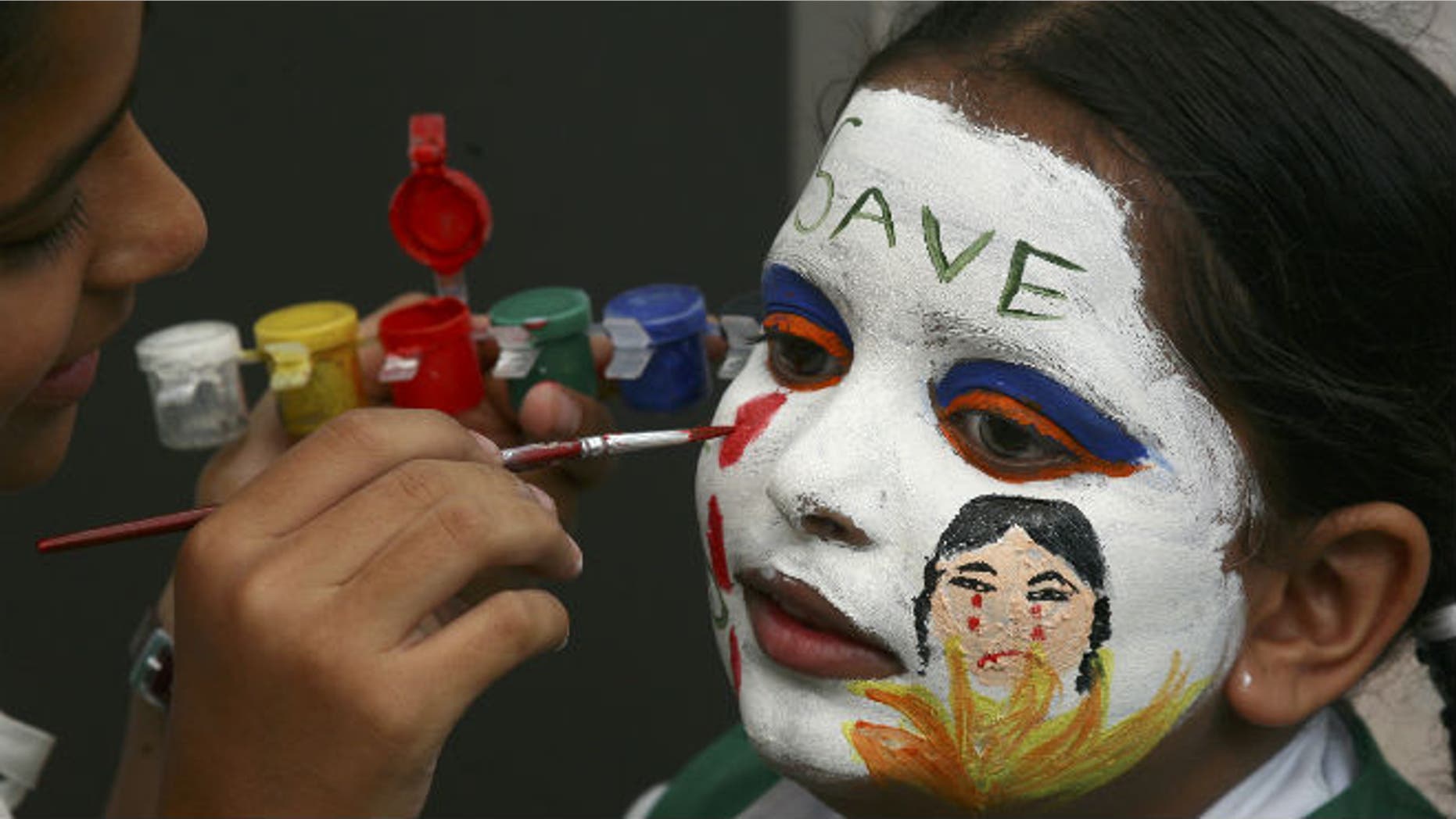 A girl gets her face painted with an awareness message on female foeticide during a face-painting competition in the northern Indian city of Chandigarh August 1, 2009. (REUTERS/Ajay Verma)
