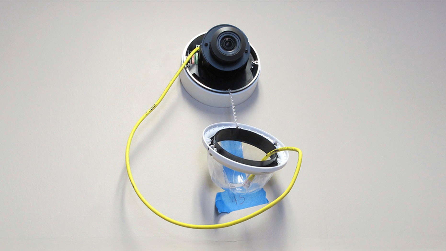 In this July 10, 2018 photo, a camera with facial recognition capabilities hangs from a wall while being installed at Lockport High School in Lockport, N.Y.