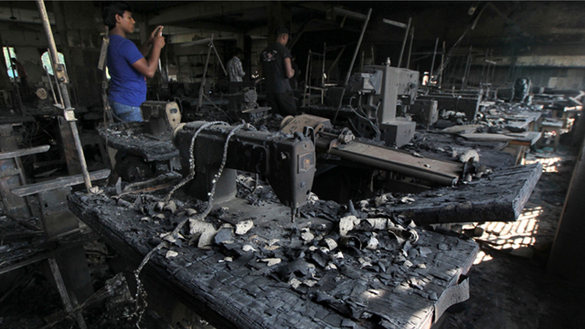 Nov. 26, 2012: A man takes photographs inside a garment-factory where a fire killed more than 110 people on the outskirts of Dhaka, Bangladesh.