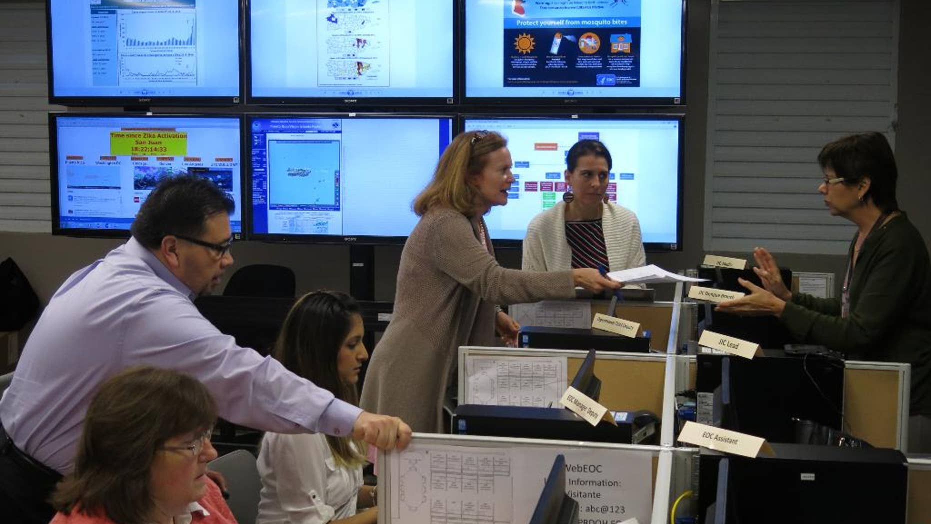 FILE - In this Feb. 24, 2016 file photo, workers from the Puerto Rico Health Department and the Centers for Disease Control and Prevention review Zika-related data collected by the island's health department and the CDC in San Juan, Puerto Rico. On Friday, June 17, 2016, Dr. Tom Frieden, the director of the CDC, is warning that dozens or hundreds of babies in Puerto Rico could develop severe birth defects because of the virus, based on how an outbreak is playing out there. (AP Photo/Danica Coto)