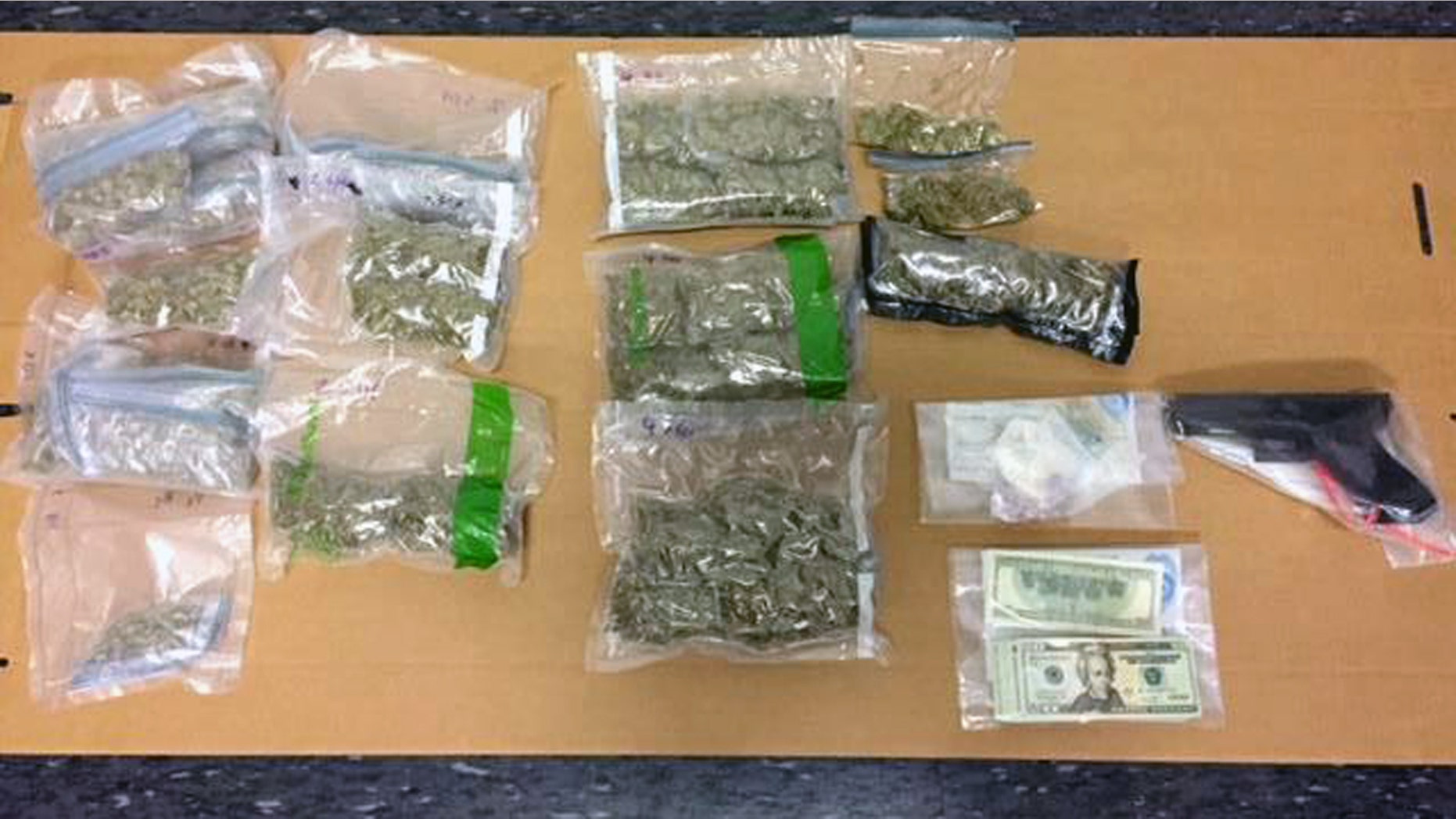 Police display marijuana and other paraphernalia seized from a suspected drug dealer