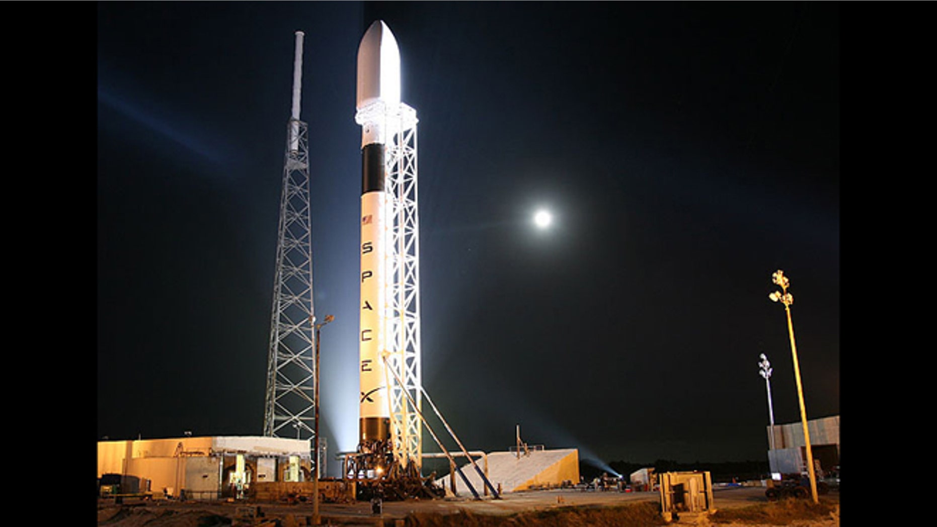 A Falcon 9 rocket from SpaceX sits on a launch pad, awaiting take off.