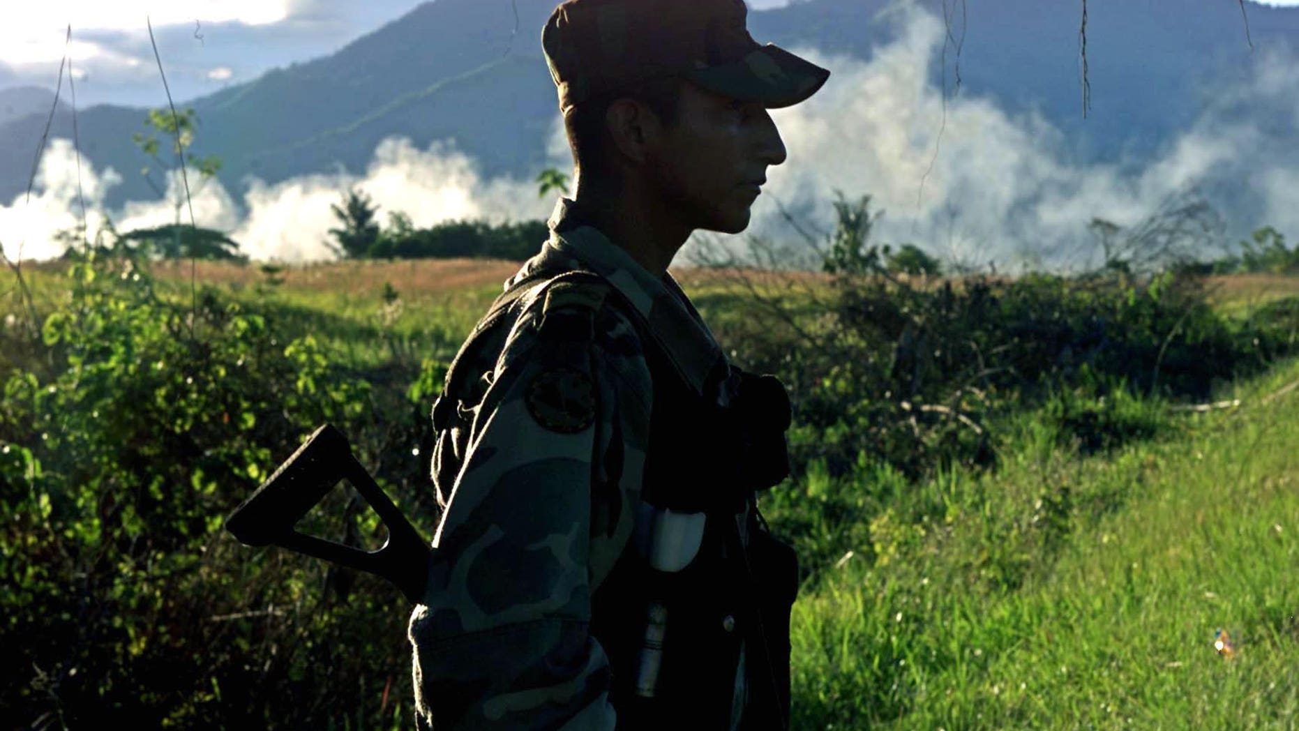CAQUETA, COLOMBIA - JULY 31. A Colombian soldier patrols the highway that leads to San Vicente del Caguan from his base, Caqueta, Colombia on July 31, 2002. Despite a strong military presence in the former demilitarized zone, FARC guerrillas still maintain their control over the territories. (Photo by Carlos Villalon/Getty Images.)