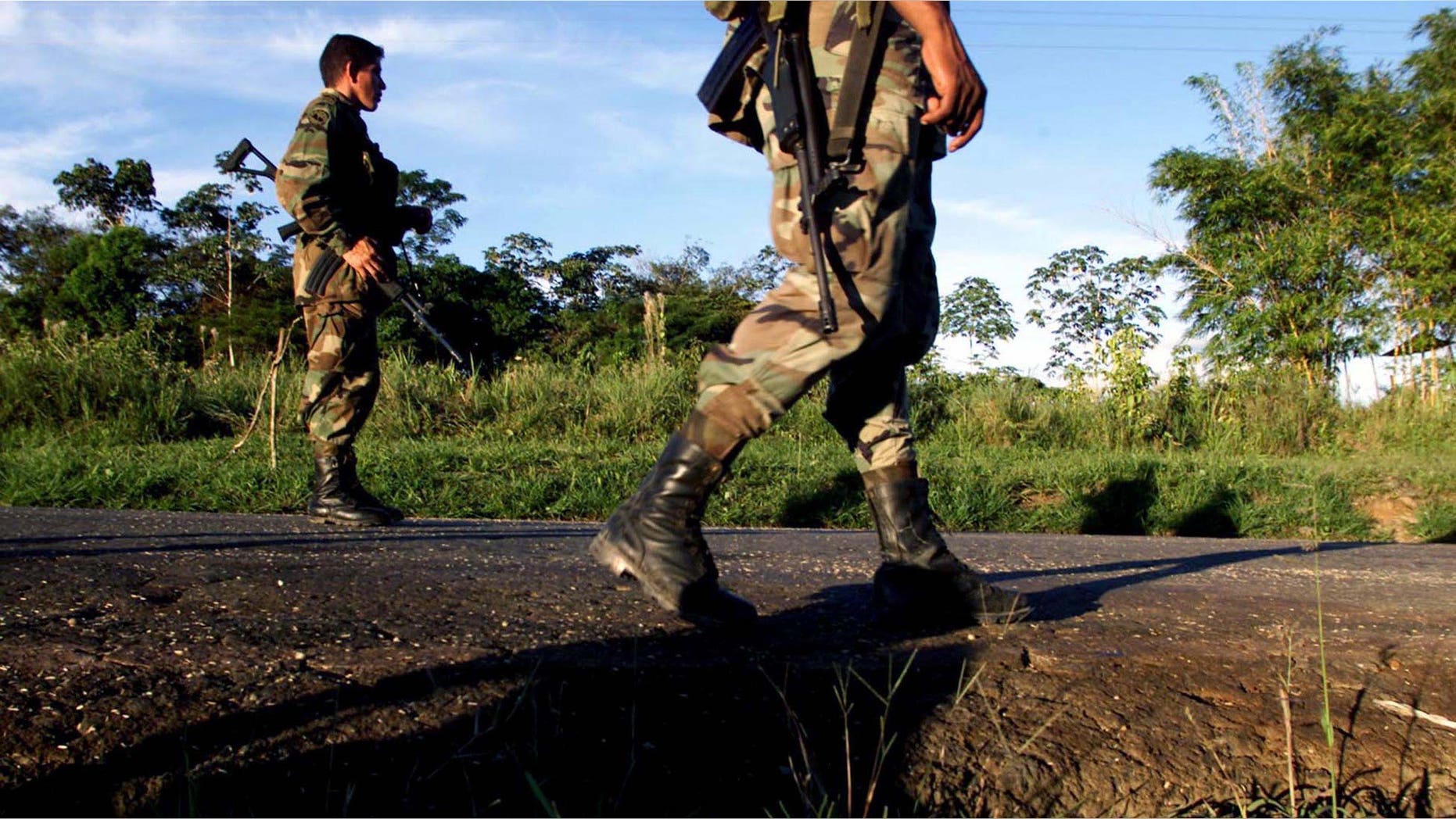 CAQUETA, COLOMBIA - JULY 31: Colombian soldiers patrol the highway that leads to San Vicente del Caguan from their base in Caqueta, Colombia on July 31, 2002. Despite a strong military presence in the former demilitarized zone, FARC guerrillas still maintain their control over the territories. (Photo by Carlos Villalon/Getty Images.)