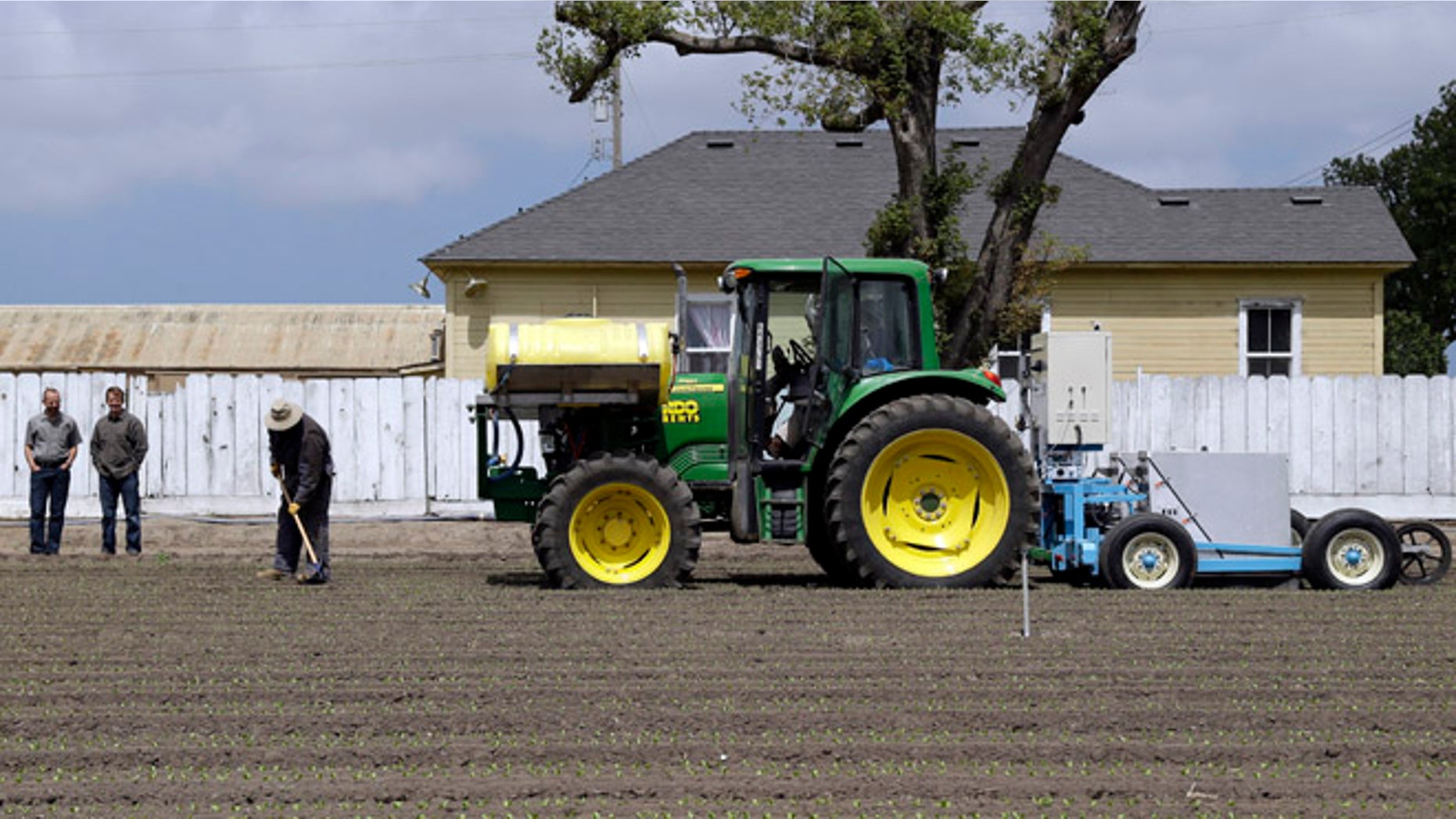 In this May 23, 2013, photo, the lettuce bot is dragged by a tractor during tests in Salinas, Calif. In the Salinas Valley, the lettuce capital of the world, entrepreneurs with the Silicon Valley company Blue River Technology are testing the Lettuce Bot, a boxy robotic machine that can thin fields of lettuce, a job that now requires detailed hand work by 20 farm workers.