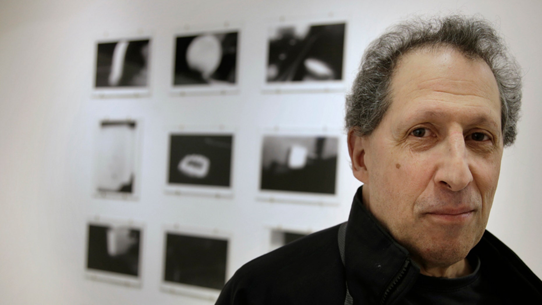 In this Wednesday, Feb. 22, 2017 photo, photographer Karl Baden, of Cambridge, Mass., stands for a photo in front of an exhibit of his photographs from 1976 called "Thermographs," at the Miller Yezerski Gallery, in Boston. On Feb. 23, 1987, long before they were called selfies, Karl Baden snapped a simple, black and white photo of himself. Then he repeated it, every day, for the next three decades. Baden's "Every Day" project turns 30 years old Thursday, Feb. 23, 2017. (AP Photo/Steven Senne)