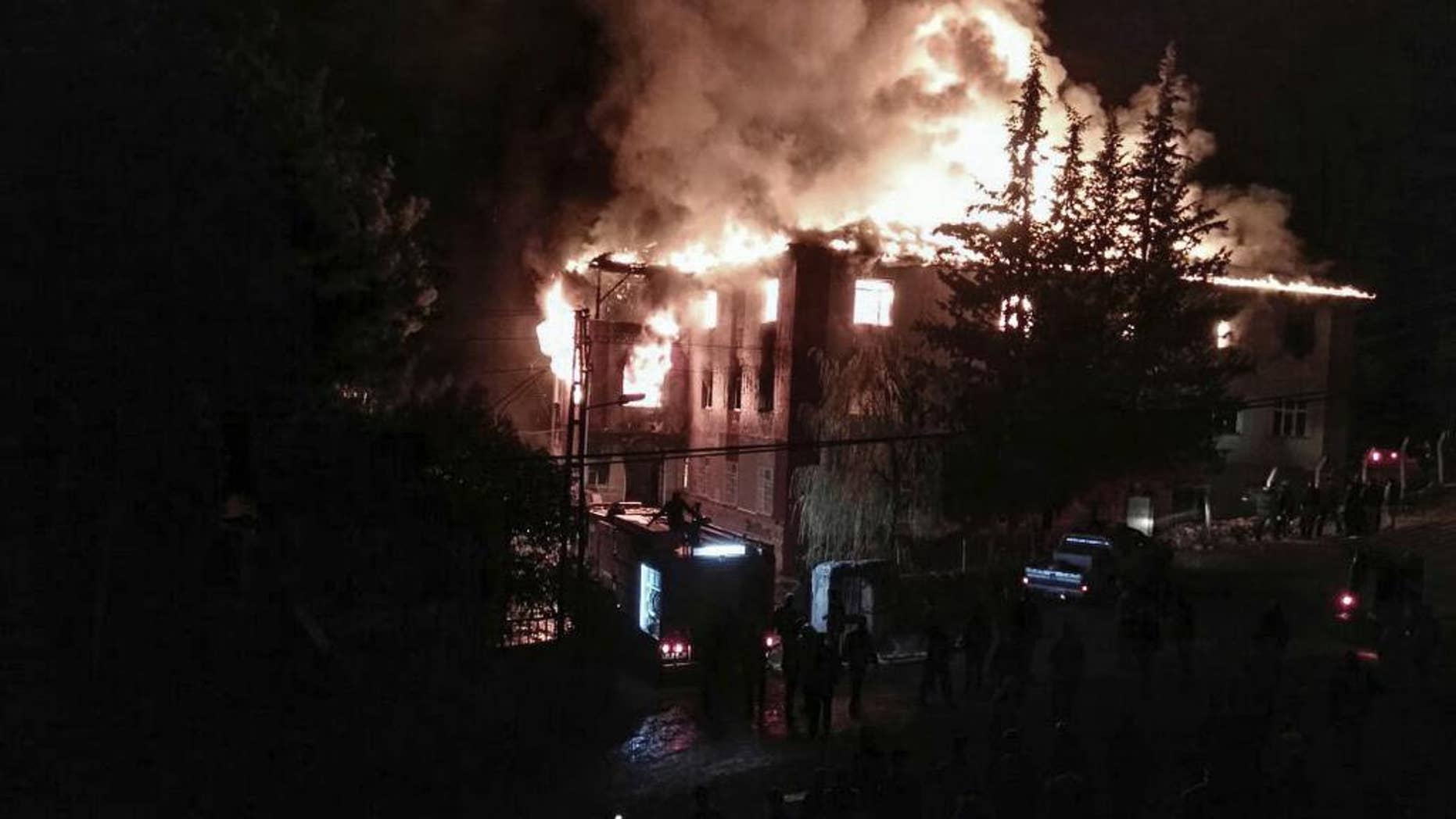Flames rise from a fire in a school dormitory, in Aladag, Adana in southern Turkey, Tuesday, Nov. 29, 2016. A fire at a middle school dormitory for girls in southern Turkey has left over ten people dead and over a dozen injured, a Turkish governor and state-run media said. (DHA via AP)