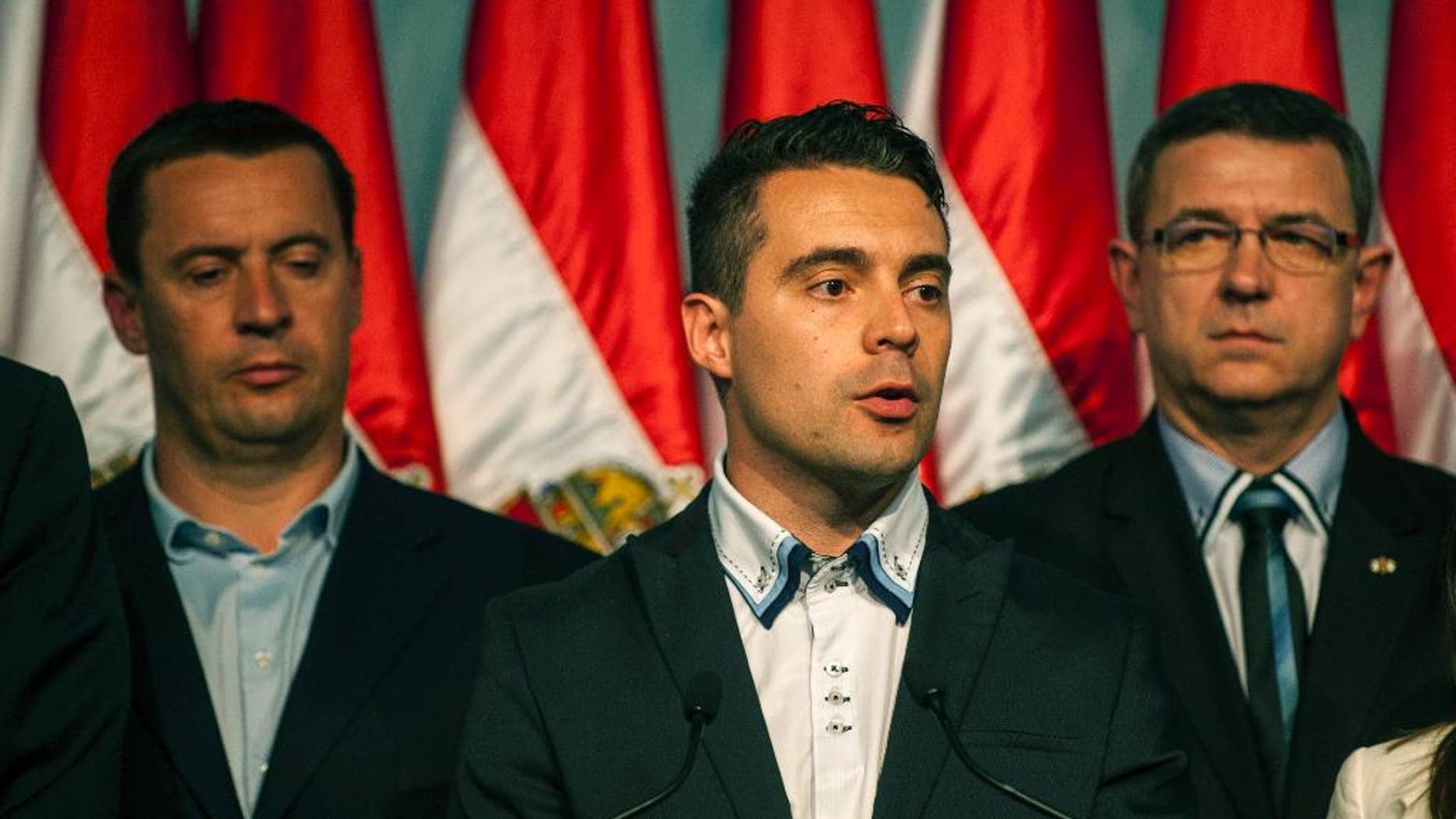 FILE - In this April 6, 2014 file picture Chairman of the radical nationalist Jobbik party Gabor Vona, center, delivers his speech after the parliamentary elections in the Budapest Congress Centre in Budapest, Hungary. Experts say the leader of Hungary's far-right Jobbik party is trying to strengthen his power by forcing a key party member to resign from parliament. Elod Novak says he is giving up his seat at the request of party president Gabor Vona but wants to remain in Jobbik. (AP Photo/MTI, Janos Marjai,file )