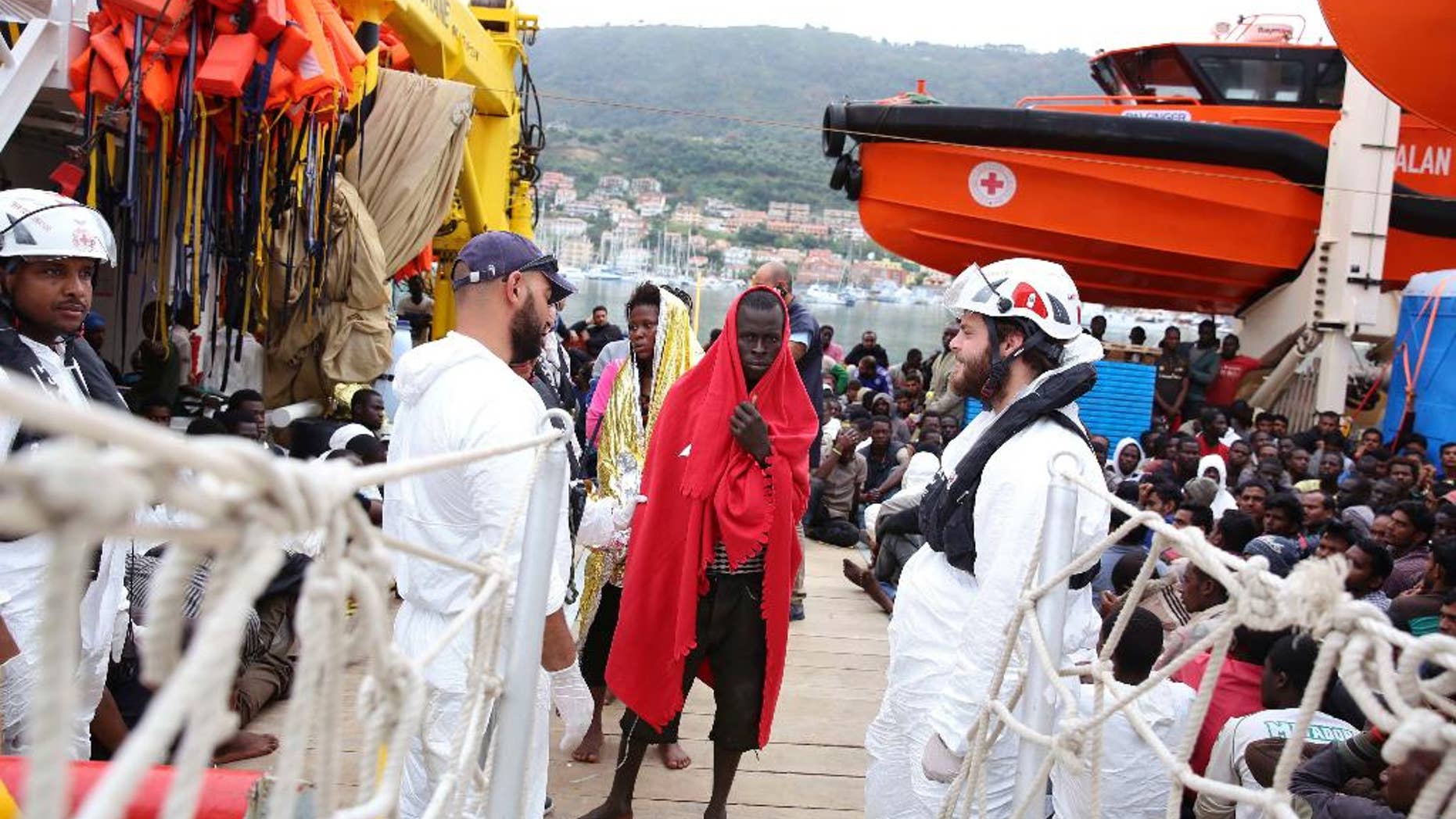Migrants wrapped in blankets disembark from the vessel Responder, run by the Malta-based NGO Migrant Offshore Aid Station (MOAS) and the Italian Red Cross, in Vibo Valentia, southern Italy, on Monday, Nov. 7, 2016. About 400 disembarked after being rescued at sea in separate operations. (Francesco Malavolta/MOAS via AP)