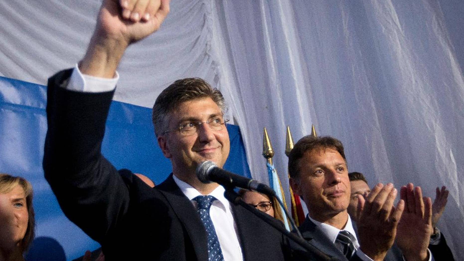 FILE - This is a Monday, Sept. 12, 2016 file photo of Andrej Plenkovic, front left, leader of center-right HDZ party as he celebrates elections results at the party's headquarters in Zagreb, Croatia. Croatia's president on Monday Oct. 10, 2016 appointed conservative leader Andrej Plenkovic as prime minister-designate after his party and a small populist group agreed to form a coalition government in a bid to end months of political instability in the EU's newest member state. (AP Photo/Darko Bandic, File)