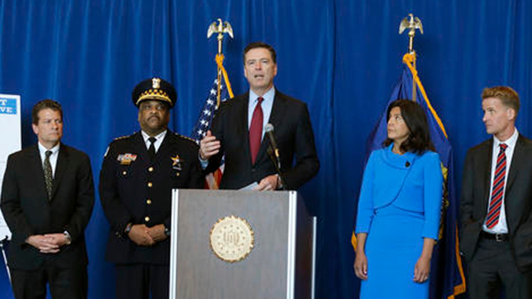 FBI Director James B. Comey, center, announces the addition of Luis Macedo to the bureau's ten most wanted list during a news conference, Thursday, May 19, 2016, in Chicago.