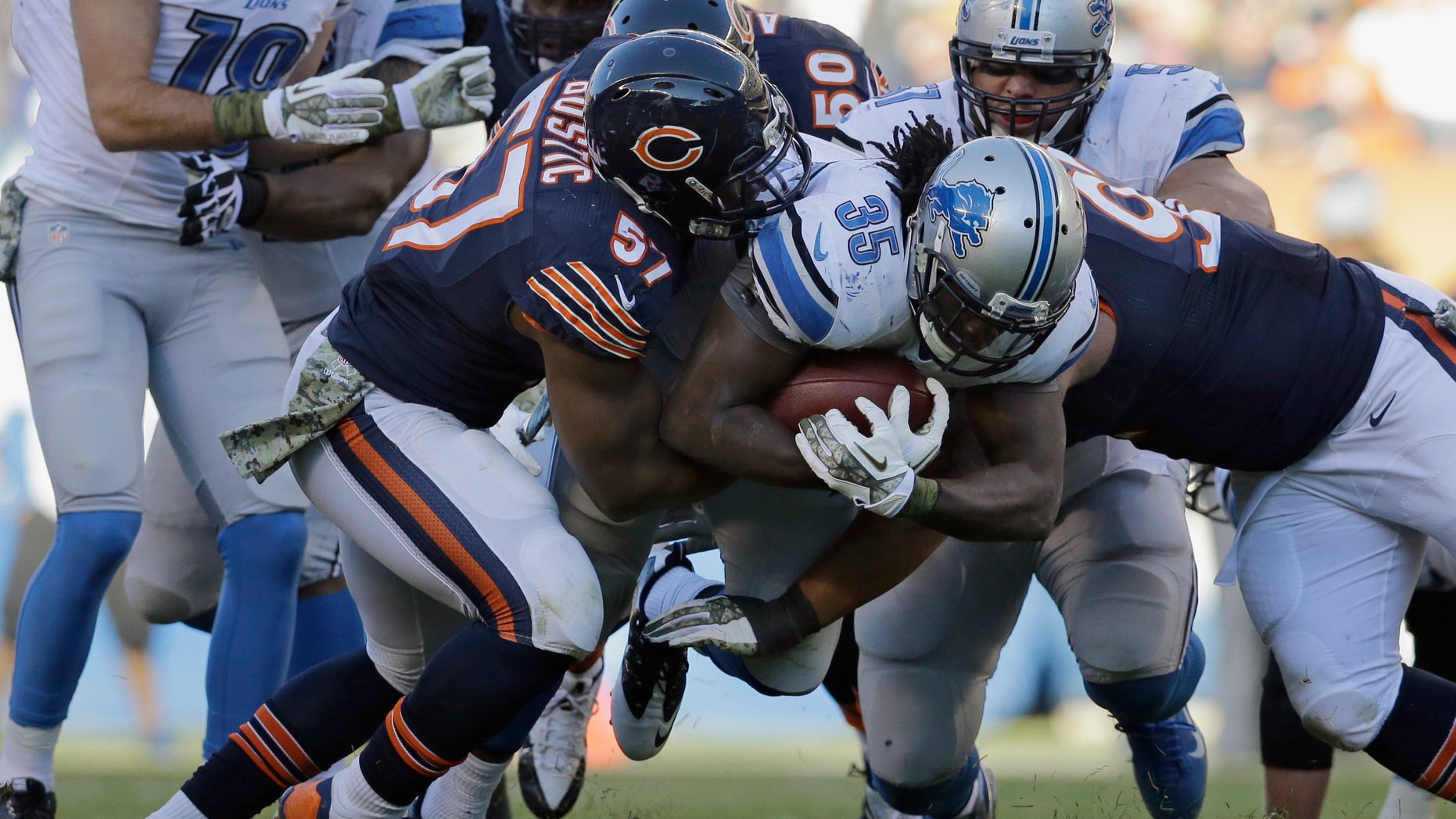Detroit Lions running back Joique Bell (35) is tackled by Chicago Bears defenders during the second half of an NFL football game, Sunday, Nov. 10, 2013, in Chicago. The Lions won 21-19. (AP Photo/Nam Y. Huh)