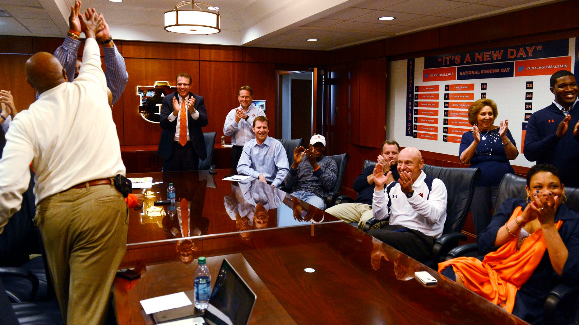 The Auburn coaching stafff reacts to watching Montravius Adams announced that was signing with the Tigers to attend Auburn and play NCAA college football on national signing day on Wednesday, Feb 6, 2013 in Auburn, Ala. Auburn coach Gus Malzahn is standing center.(AP Photo/Todd J. Van Emst)