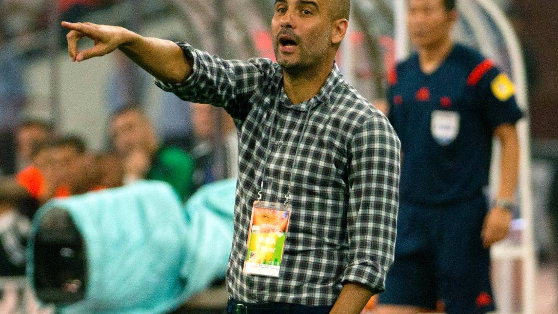 Bayern head coach Pep Guardiola gives instructions to his team during the second half of their friendly soccer match against Valencia in Beijing, Saturday, July 18, 2015. Bayern Munich beat Valencia, 4-1. (AP Photo/Mark Schiefelbein)