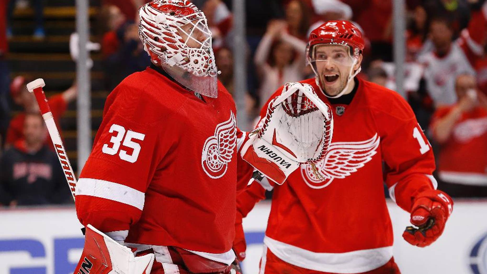 Detroit Red Wings goalie Jimmy Howard (35) celebrates with Detroit Red Wings center Pavel Datsyuk after beating the Carolina Hurricanes 3-2 in an NHL hockey game in Detroit Tuesday, April 7, 2015. (AP Photo/Paul Sancya)