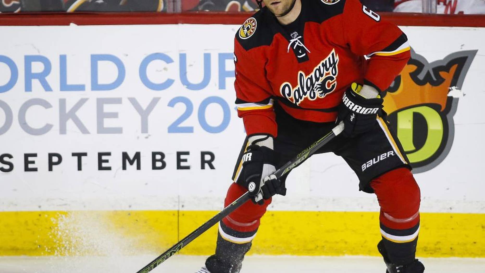 File-This March 11, 2016, file photo shows Calgary Flames' Dennis Wideman handling the puck during the first period of an NHL hockey game against the Arizona Coyotes,in Calgary, Alberta. The national Hockey League asked a Manhattan federal court judge Wednesday, June 8, 2016, to reject the reduction of Calgary Flames defenseman Dennis Wideman’s suspension for knocking down a linesman. An independent arbitrator reduced Wideman's suspension from 20 games to 10 after ruling that Wideman did not intend to injure linesman Don Henderson in Jan. 27 game against the Nashville Predators. The suspension has already been served. (Jeff McIntosh/The Canadian Press via AP) MANDATORY CREDIT