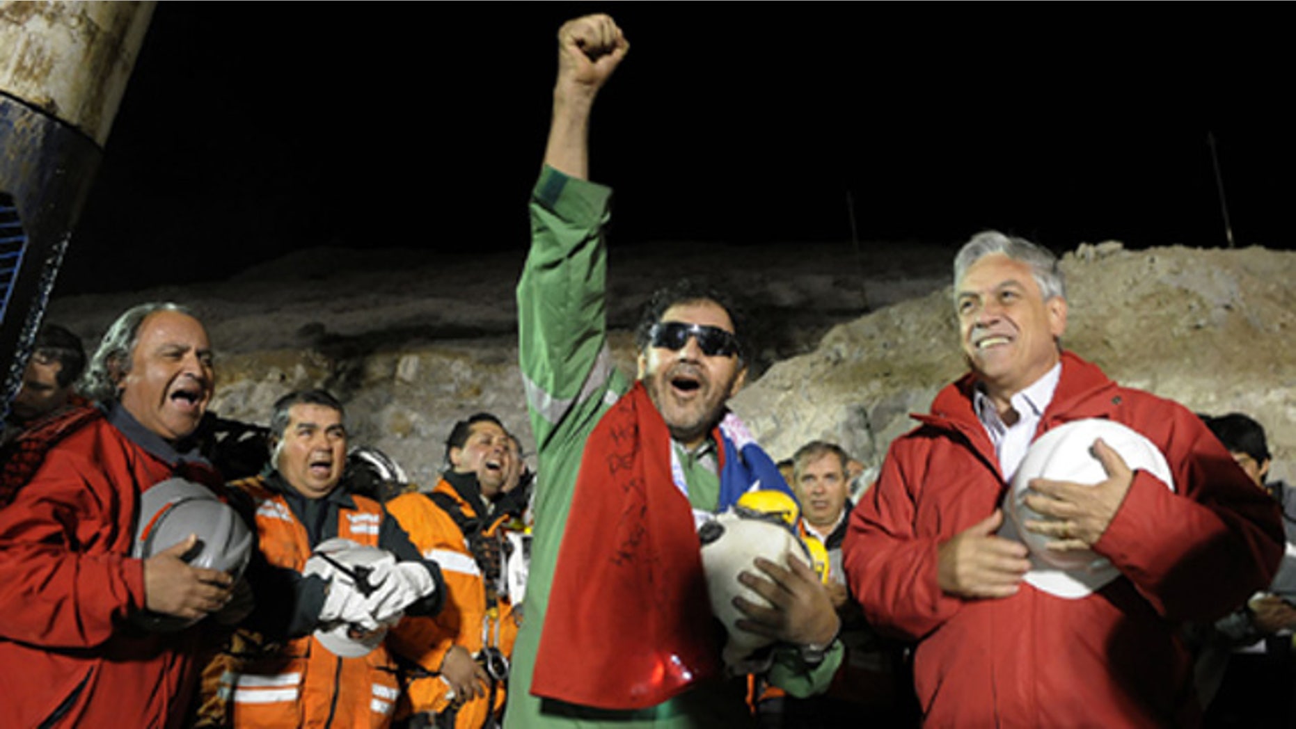In this photo released by the Chilean Presidential Press Office, the last miner to be rescued, Luis Urzua, center, gestures as Chile's President Sebastian Pinera, right, looks on after his rescue from the collapsed San Jose gold and copper mine where he had been trapped with 32 other miners for over two months near Copiapo, Chile, Wednesday Oct. 13, 2010. The 69-day underground ordeal reached its end Wednesday night after 33 trapped miners were hauled up in a cage through a narrow hole drilled through 2,000 feet of rock. (AP Photo/Alex Ibanez, Chilean Presidential Press Office)