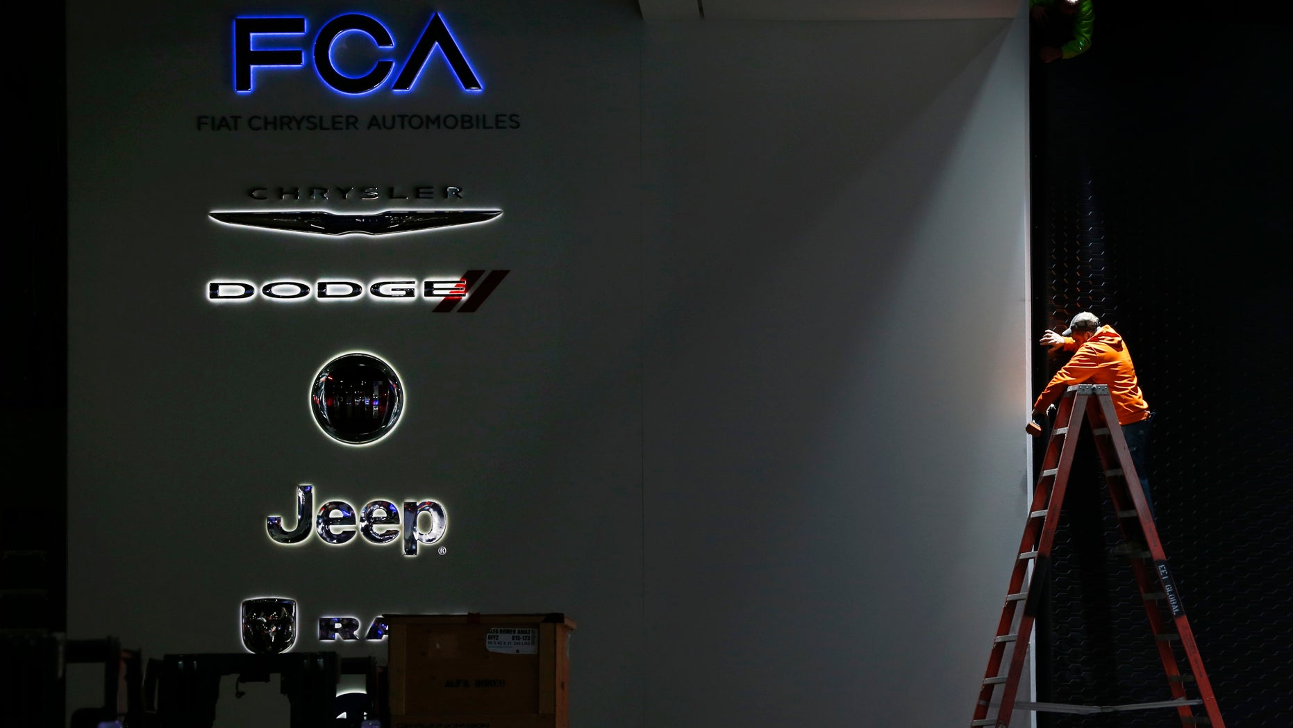 FILE - In this Thursday, Jan. 7, 2016, file photo, a worker prepares the Fiat Chrysler Automobiles area for the North American International Auto Show in Detroit. Fiat Chrysler Automobiles announced Thursday, Sept. 15, 2016, that the company is recalling more than 1.9 million vehicles worldwide because their air bags might not deploy in a crash. The recall affects certain Chrysler, Dodge, Jeep and Lancia vehicles from the 2010-2014 model years. (AP Photo/Paul Sancya, File)