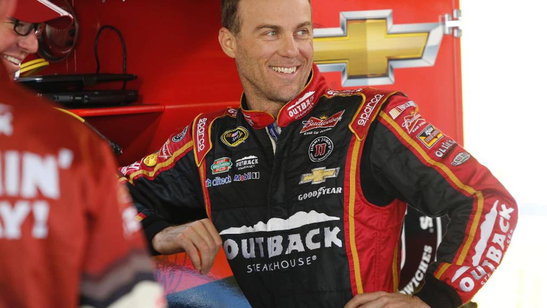 Kevin Harvick talks to his crew in the garage as he waits for practice to begin for Sunday's Sprint Cup Series auto race at Martinsville Speedway in Martinsville, Va., Saturday, Oct. 25, 2014. (AP Photo/Steve Helber)