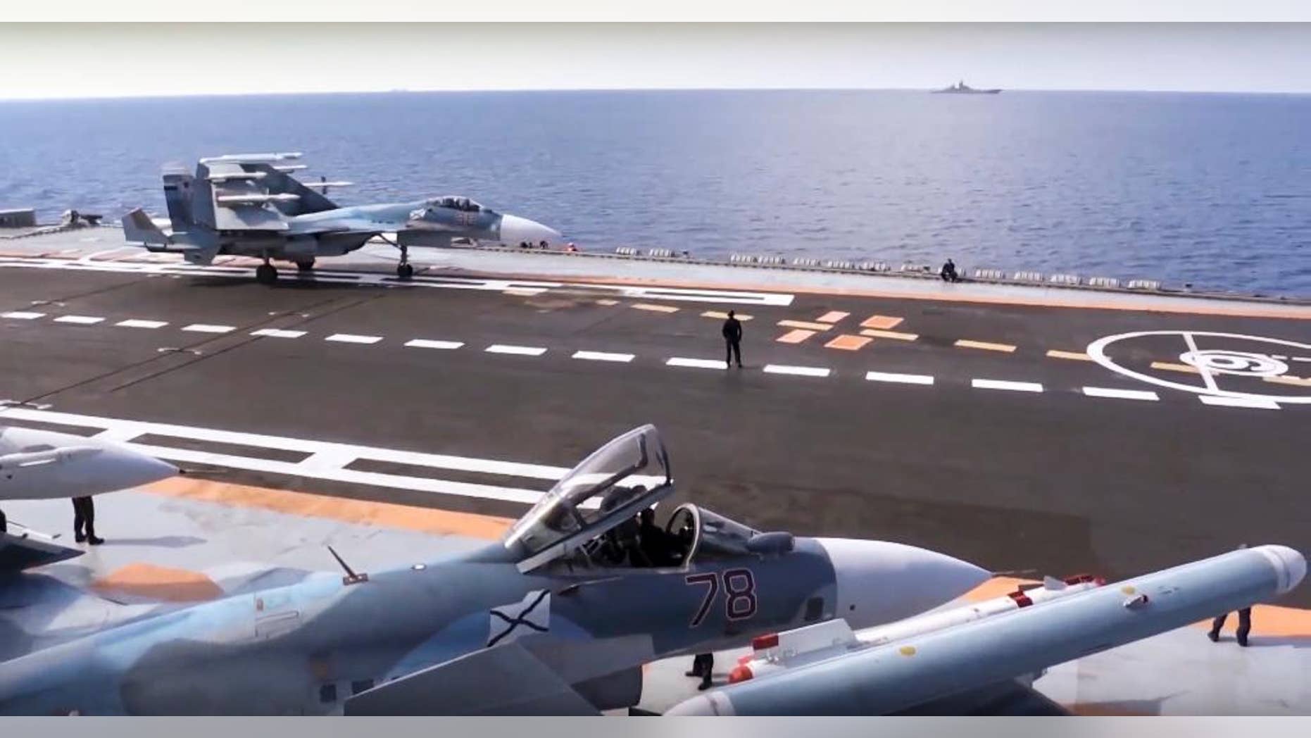 FILE - In this file photo made from the footage taken from Russian Defense Ministry official web site on Tuesday, Nov. 15, 2016, Russian Su-33 fighter jets stand on the flight deck of the Admiral Kuznetsov aircraft carrier in the eastern Mediterranean Sea. Russia says it is withdrawing the Admiral Kuznetsov aircraft carrier and some other warships from the waters off Syria as the first step in drawing down forces in Syria. (Russian Defense Ministry Press Service/ Photo via AP, File)