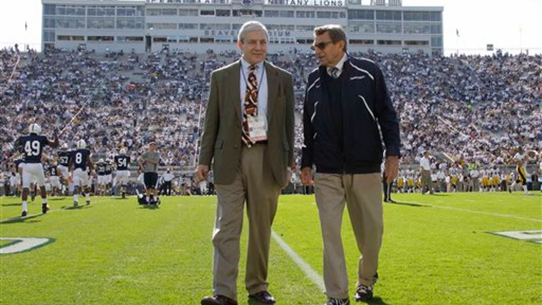 In this file photo, Penn State president Graham Spanier, left, and head football coach Joe Paterno chat before an NCAA college football game against Iowa in State College, Pa. (AP)