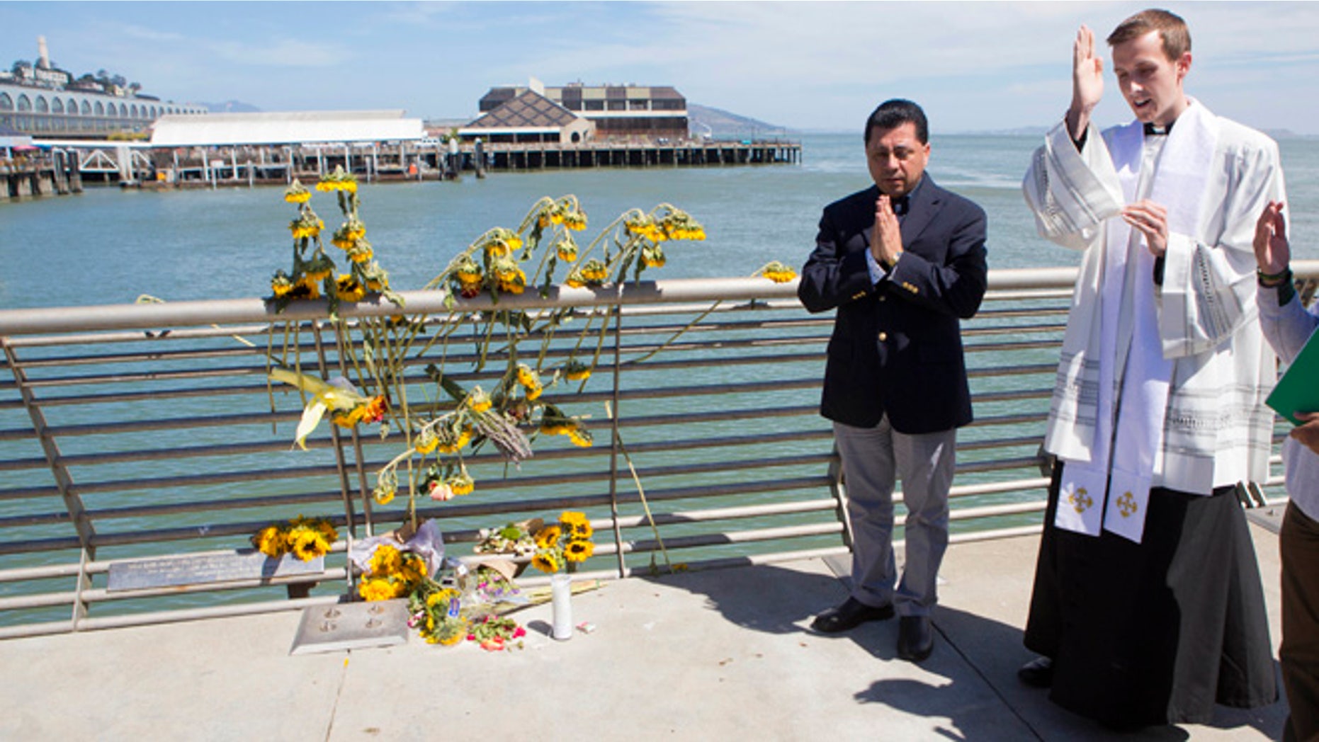 Father Cameron Faller and Julio Escobar conduct a vigil for Kathryn Steinle on Pier 14 in San Francisco, July 6, 2015.