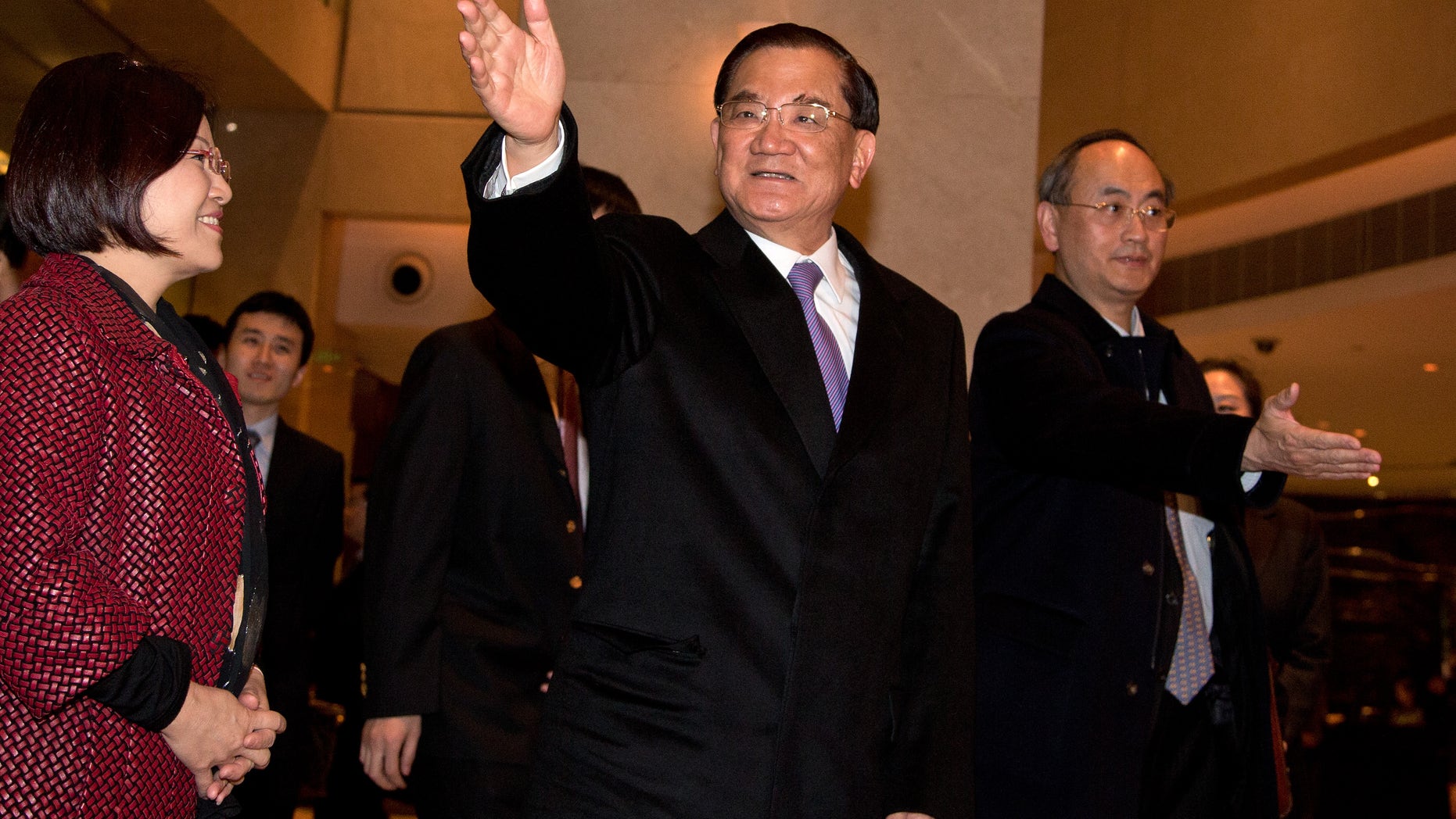 Taiwan's former vice president Lien Chan, center, waves to journalists upon arrival at a hotel in Beijing Sunday, Feb. 24, 2013. Lien Chan leads a business and politician delegation to Beijing for a three day visit and will meet with Chinese President Hu Jintao and Communist Party Secretary General and the country's new leader Xi Jinping. (AP Photo/Andy Wong)