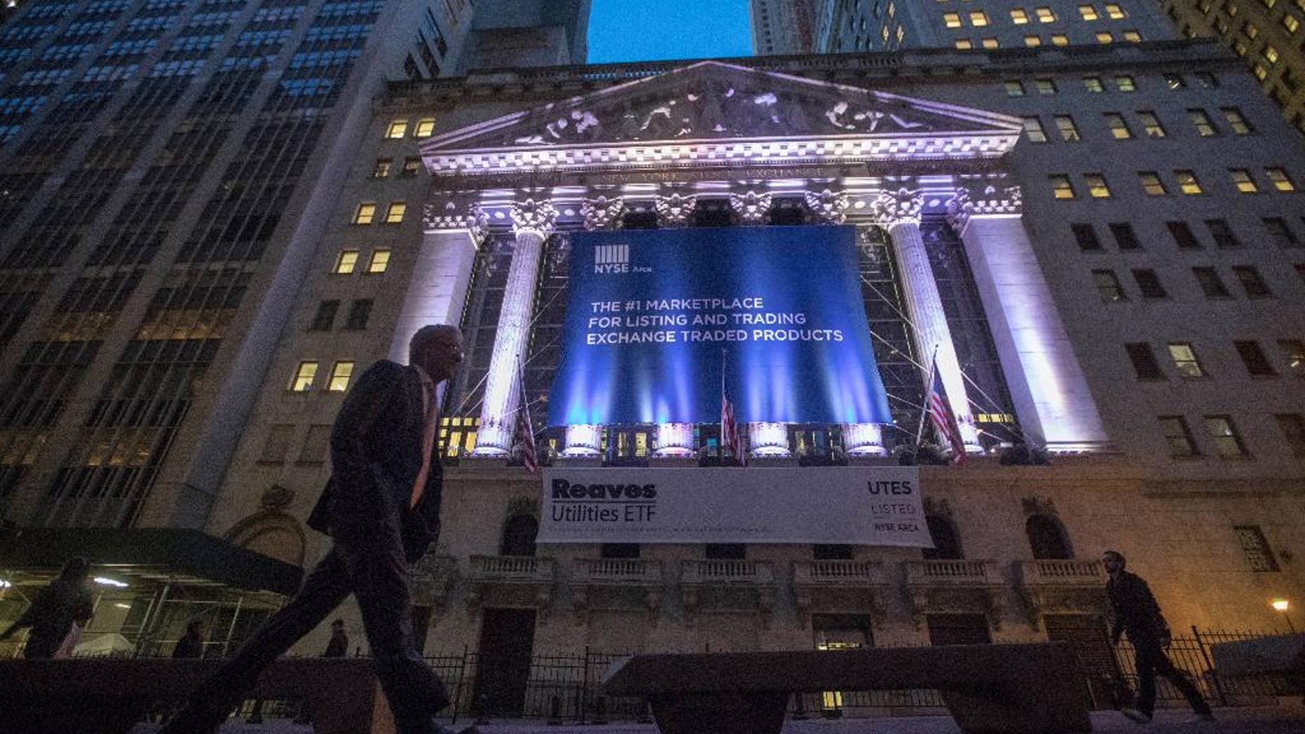 FILE - In this Oct. 25, 2016, photo, a pedestrian passes the New York Stock Exchange, in lower Manhattan. U.S. stocks edged higher Friday morning, Dec. 30, 2016, on the final day of trading for the year. High-dividend stocks like phone companies and utilities fell the most, giving back some of the gains from a day earlier. Real estate stocks led the gainers. Trading was quiet ahead of the New Year's Day holiday. (AP Photo/Mary Altaffer, File)