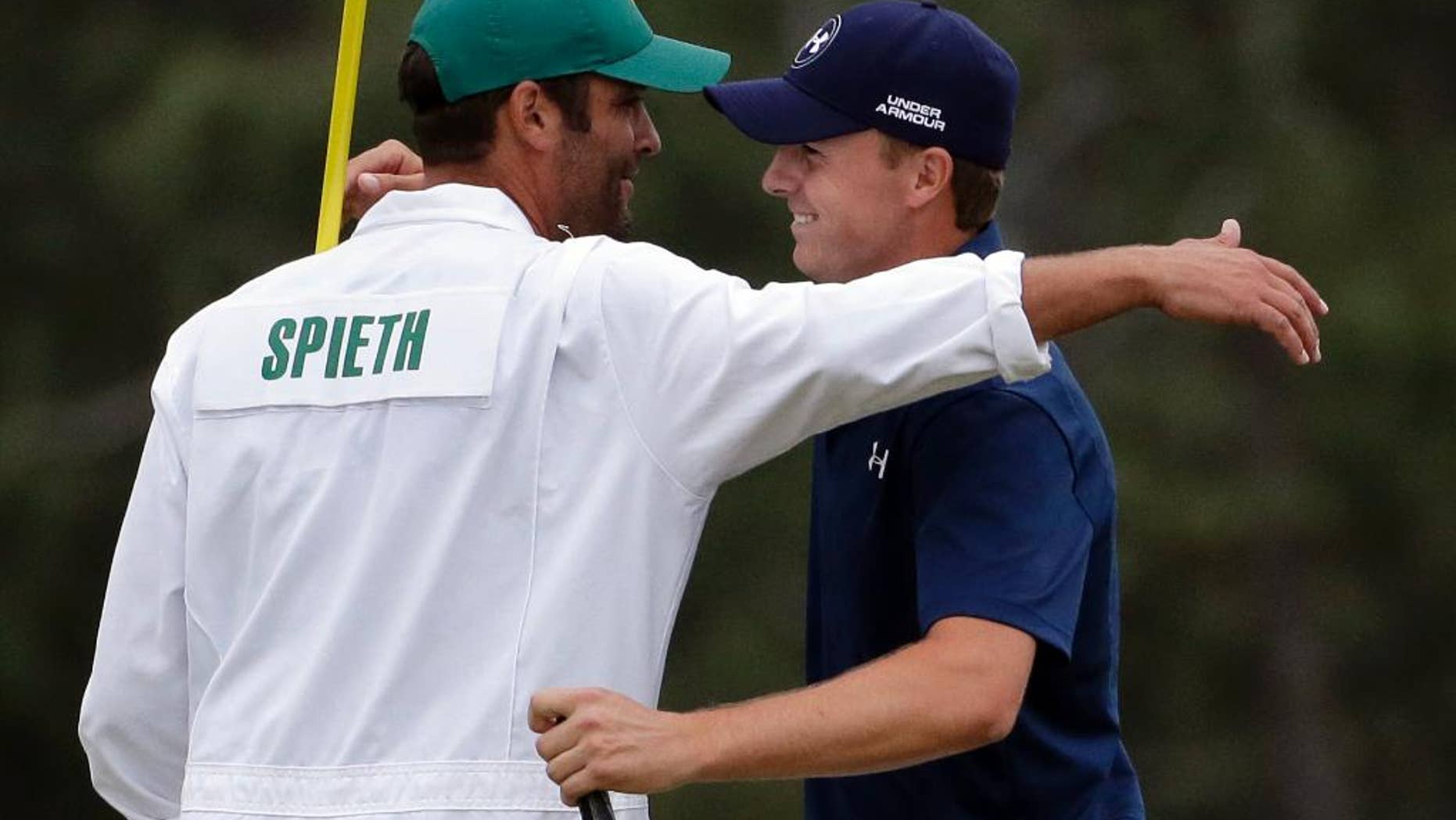 Jordan Spieth hugs his caddie Michael Greller after winning the Masters golf tournament Sunday, April 12, 2015, in Augusta, Ga. (AP Photo/Chris Carlson)