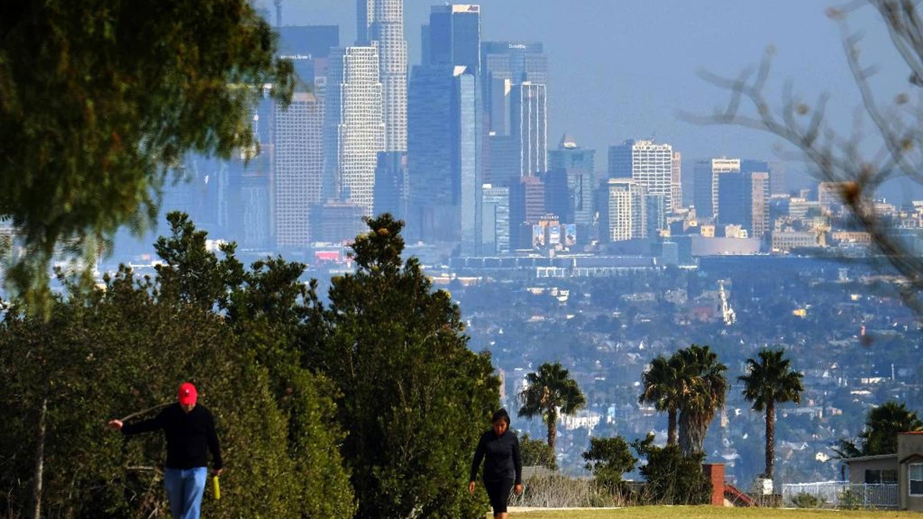 Hikers walk along a path at the Kenneth Hahn State Recreation Area near downtown Los Angeles on Sunday, Jan. 3, 2016. Southern California is bracing for a series of storms expected to begin late Sunday that could last all week. (AP Photo/Richard Vogel)