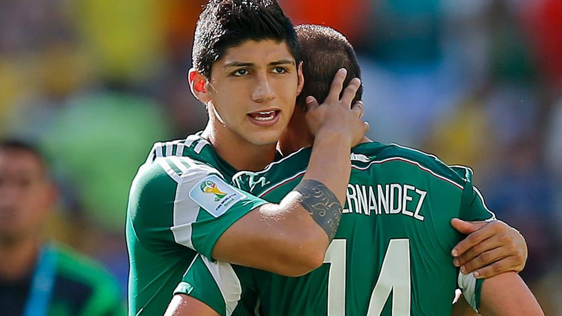 FILE - In a June 29, 2014 file photo, Mexico's Alan Pulido consoles teammate Javier Hernandez (14) after the Netherlands defeated Mexico 2-1 during the World Cup round of 16 soccer match between the Netherlands and Mexico at the Arena Castelao in Fortaleza, Brazil. A state official says that Mexican soccer star Alan Pulido has been kidnapped in the northern border state of Tamaulipas. The official says the 25-year-old player was kidnapped near his hometown of Ciudad Victoria on Sunday after leaving a party. (AP Photo/Eduardo Verdugo, File)
