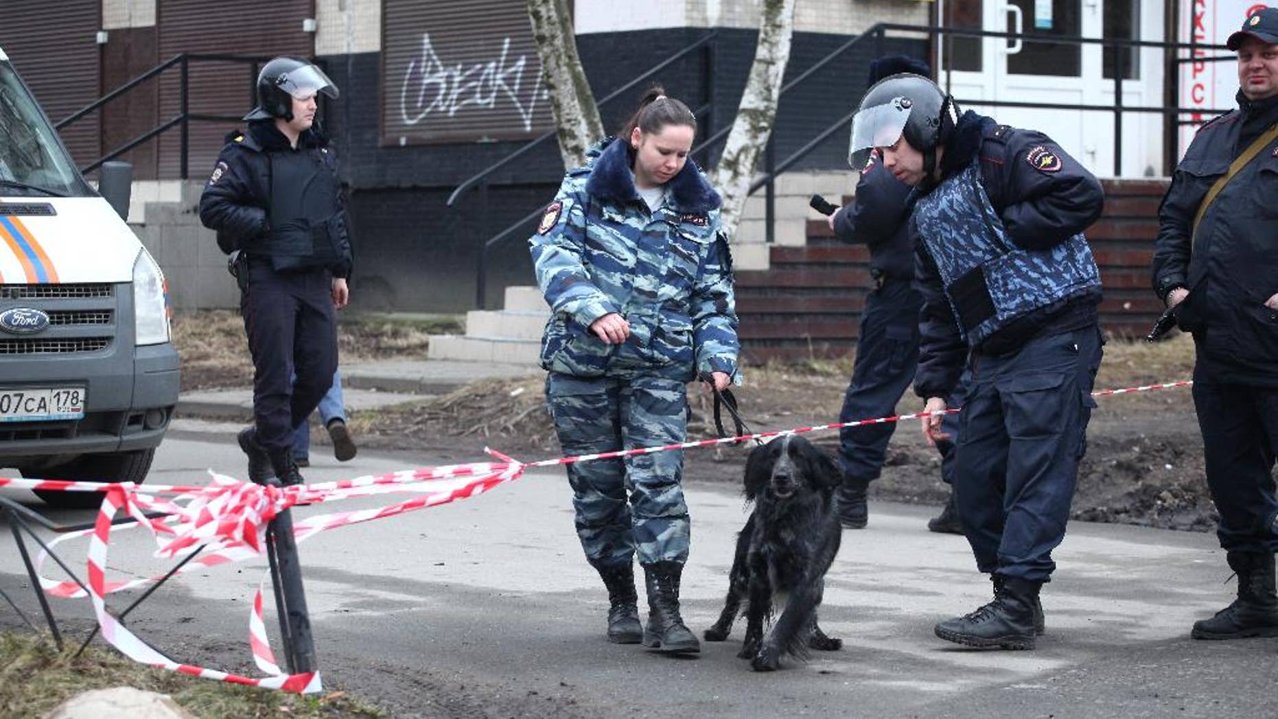 A Russian police officer with a sniffing dog crossing a police line in St. Petersburg Thursday.