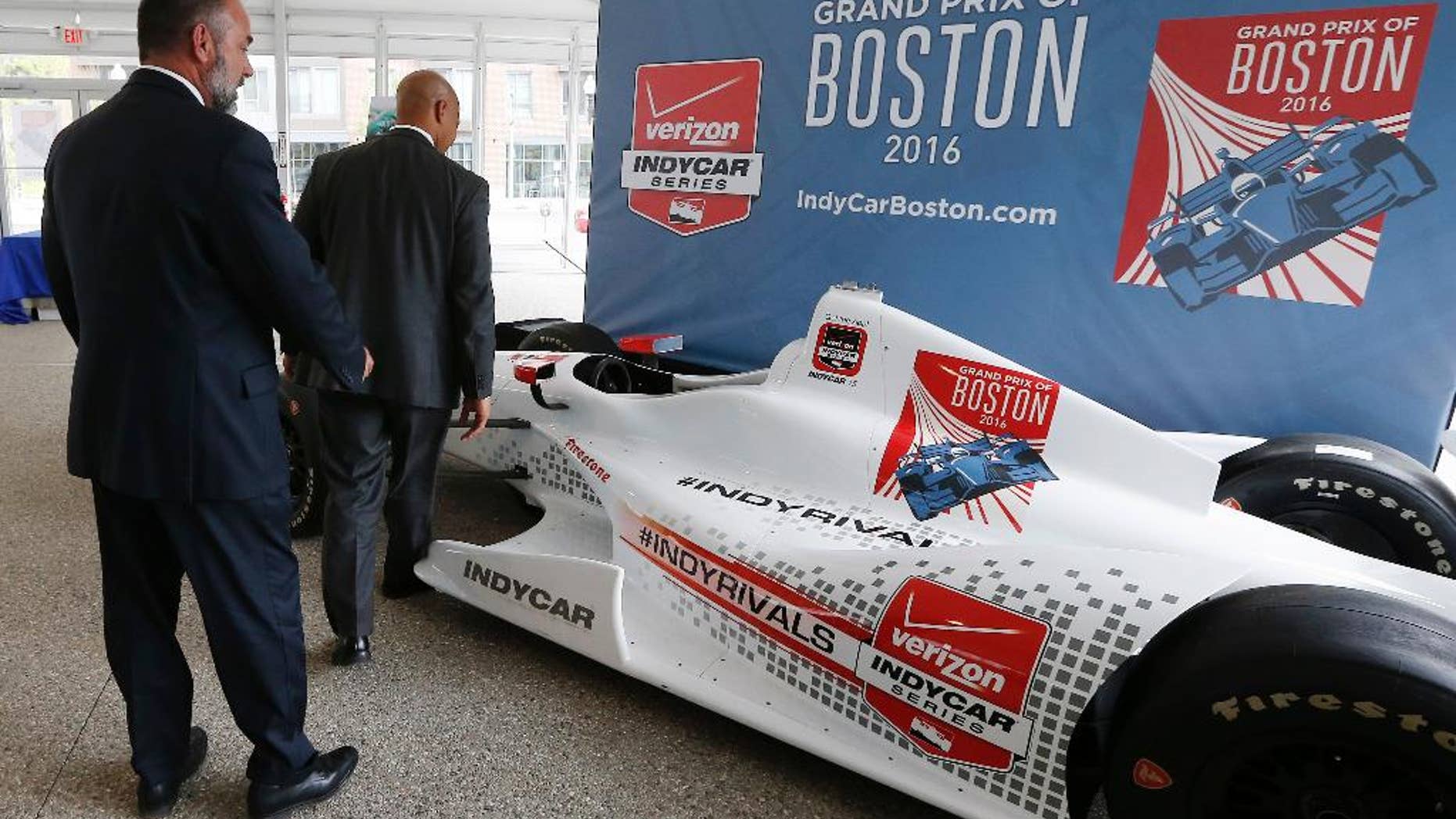 FILE - In this May 21, 2015, file photo, City of Boston chief of economic development John Barros, right, and tourism, sports and entertainment director Ken Brissette, left, examine an IndyCar mockup following a news conference in Boston announcing the inaugural Grand Prix of Boston scheduled for 2016. Organizers of the race, which had been planned for Labor Day weekend this year and again each year through 2020, told the open wheel circuit Friday, April 29, 2016, that they have scratched plans to bring a race to the city. (AP Photo/Michael Dwyer, File)