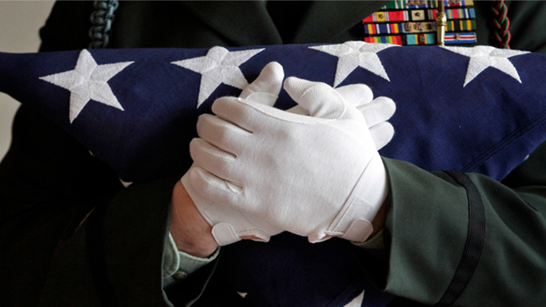 A National Guard captain holds a folded American flag.