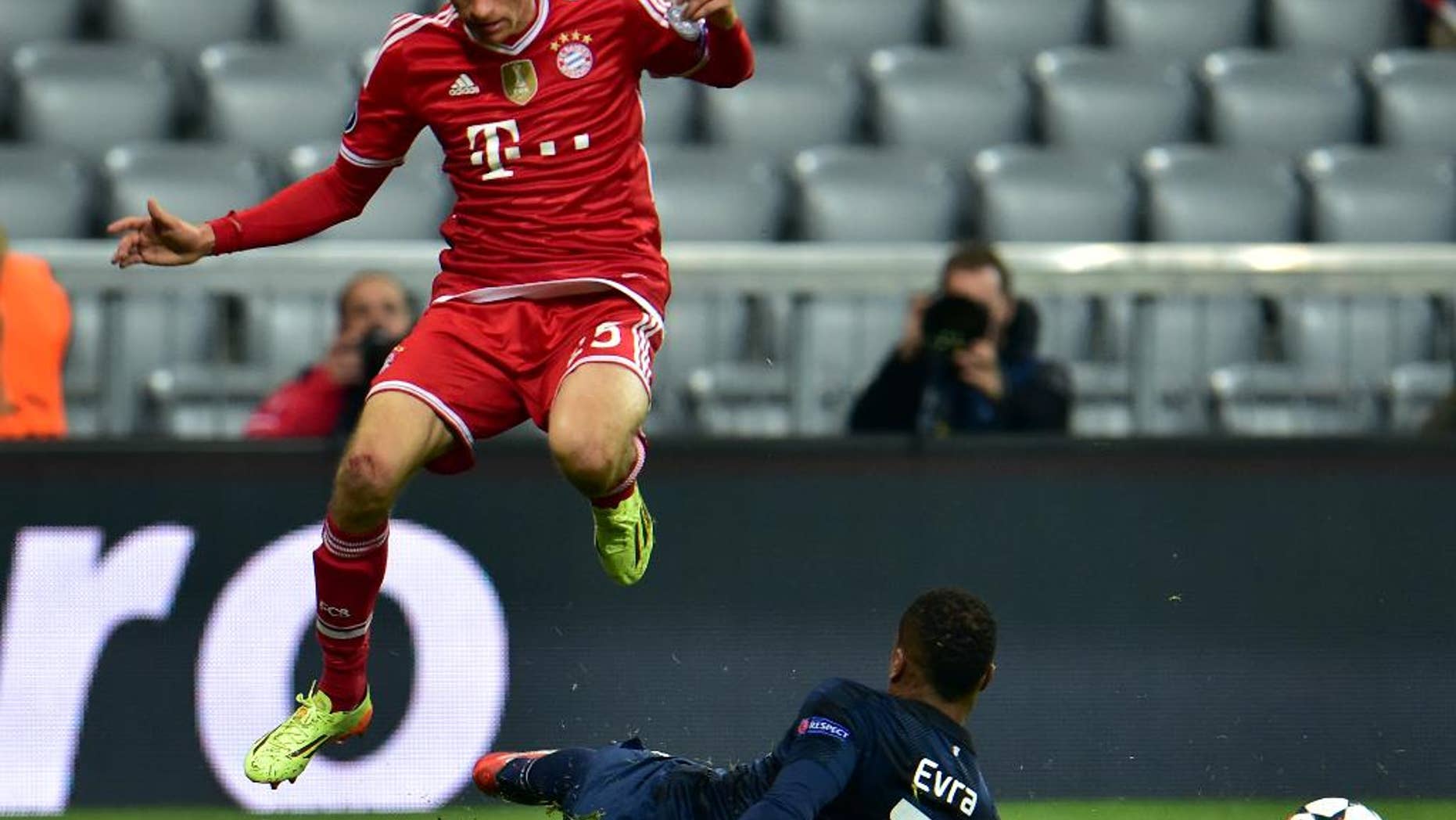 Bayern's Thomas Mueller, left, and Manchester United's Patrice Evra, right, challenge for the ball during the Champions League quarterfinal second leg soccer match between Bayern Munich and Manchester United in the Allianz Arena in Munich, Germany, Wednesday, April 9, 2014. (AP Photo/Kerstin Joensson)